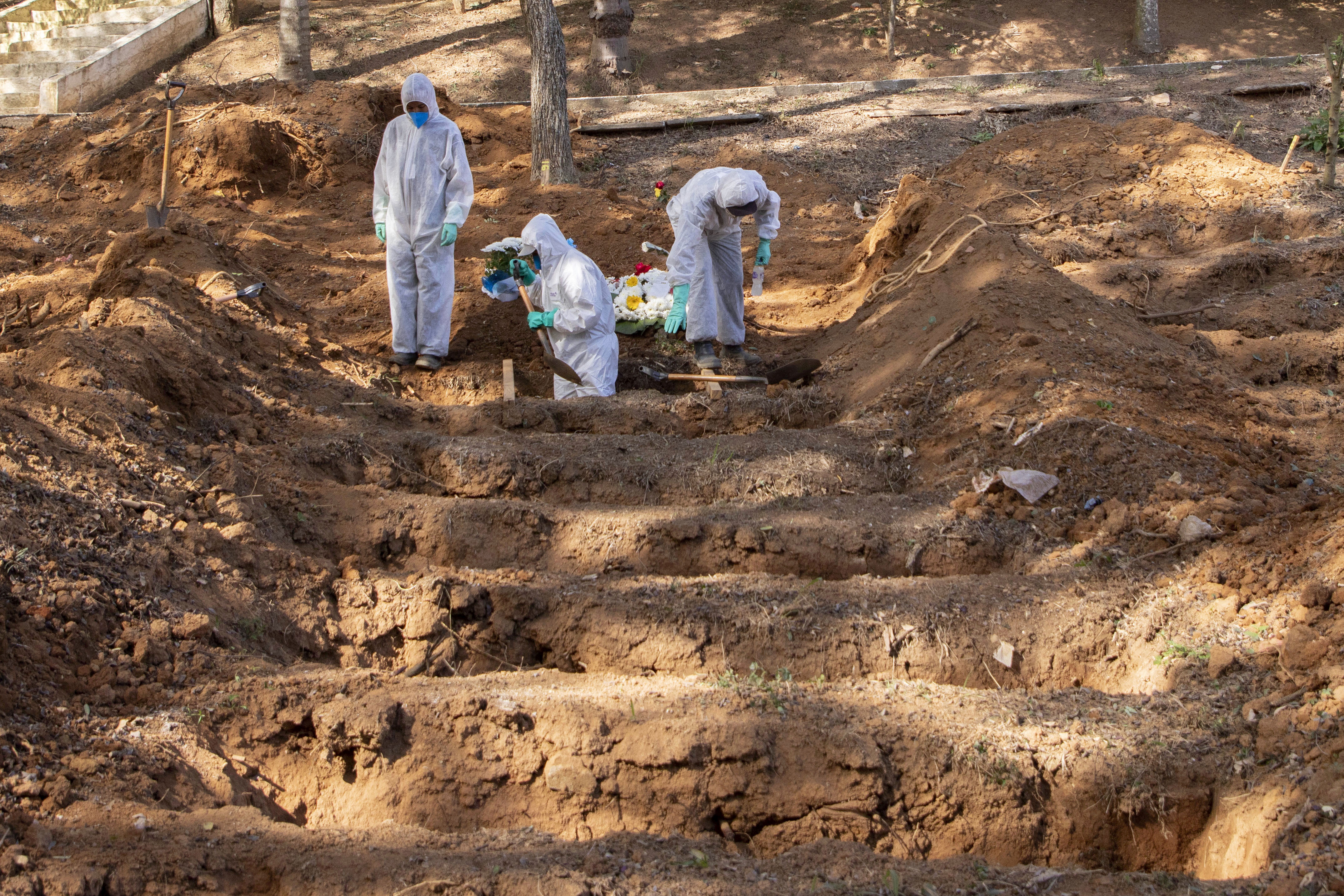Gravediggers work to bury a person said to have died from Covid-19 at a cemetery in São Paulo, Brazil, on June 23.