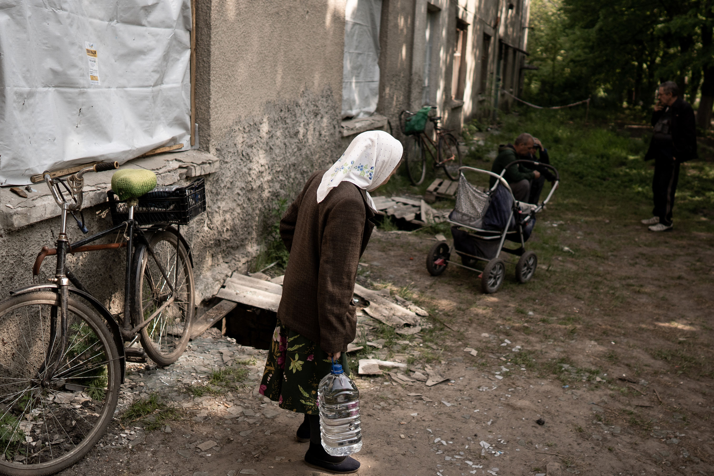 An elderly woman receives provisions from volunteers in Chasiv Yar, Ukraine on May 14. 