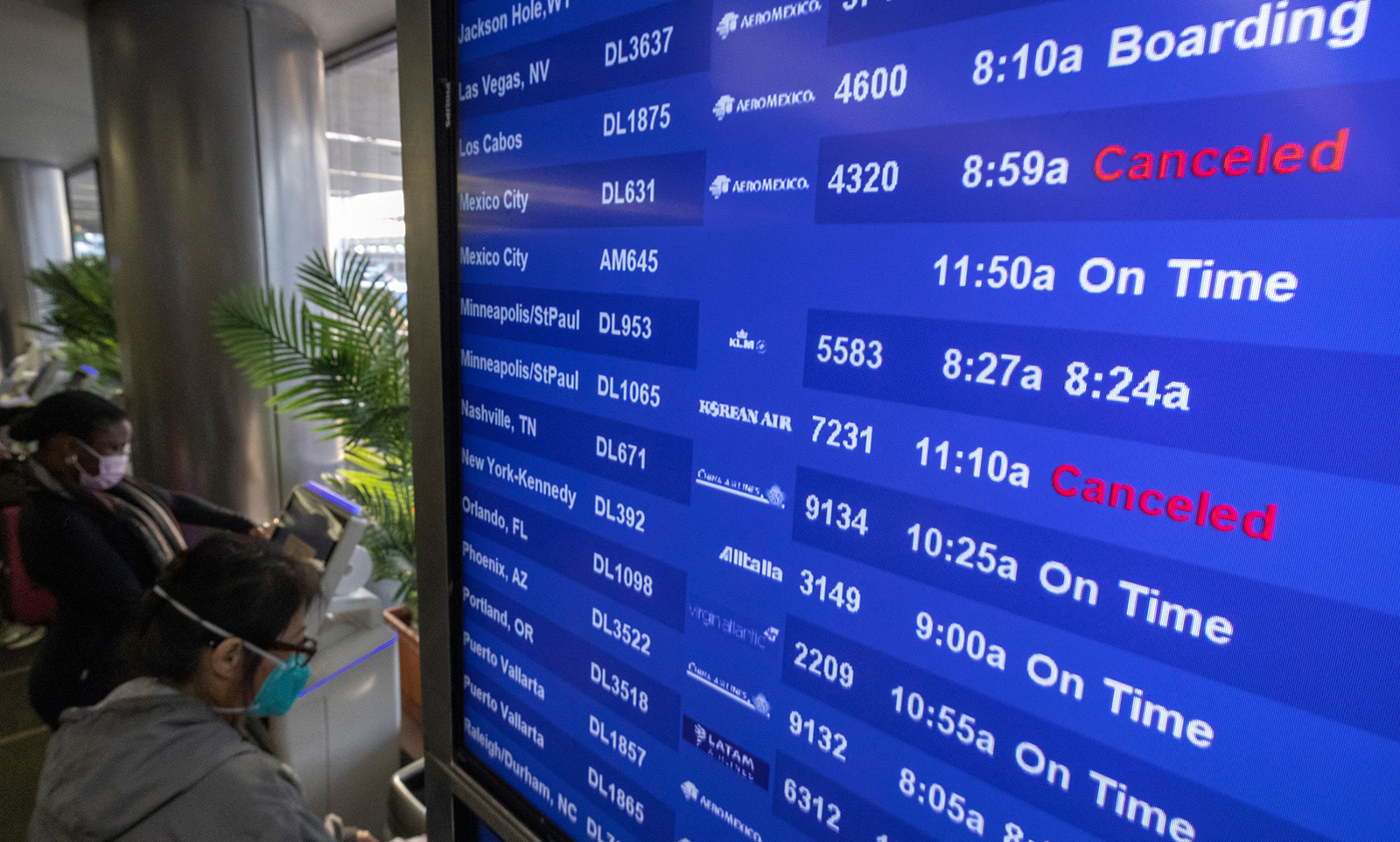 Travelers check for flight information at Los Angeles International Airport in Los Angeles, California, on December 24.