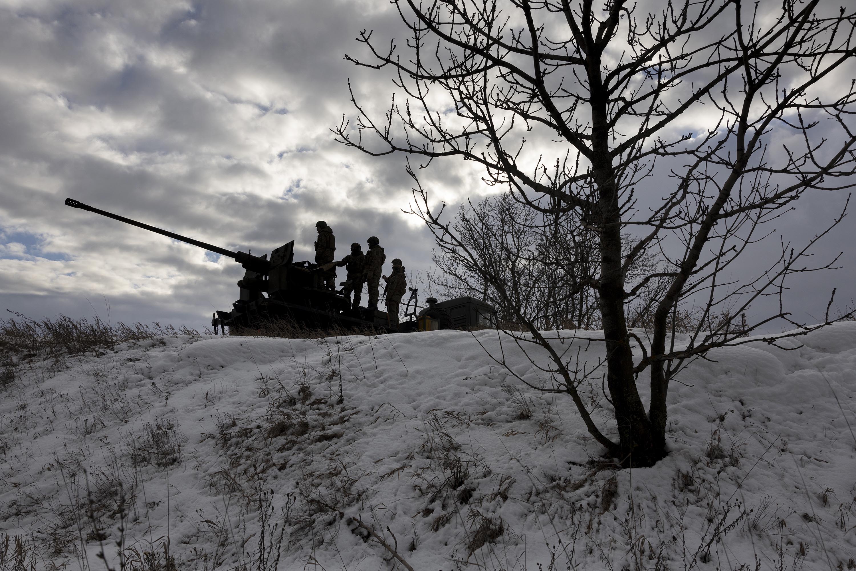 Ukrainian soldiers look towards Russian positions while atop an anti-aircraft gun on February 14, near Bakhmut, Ukraine.
