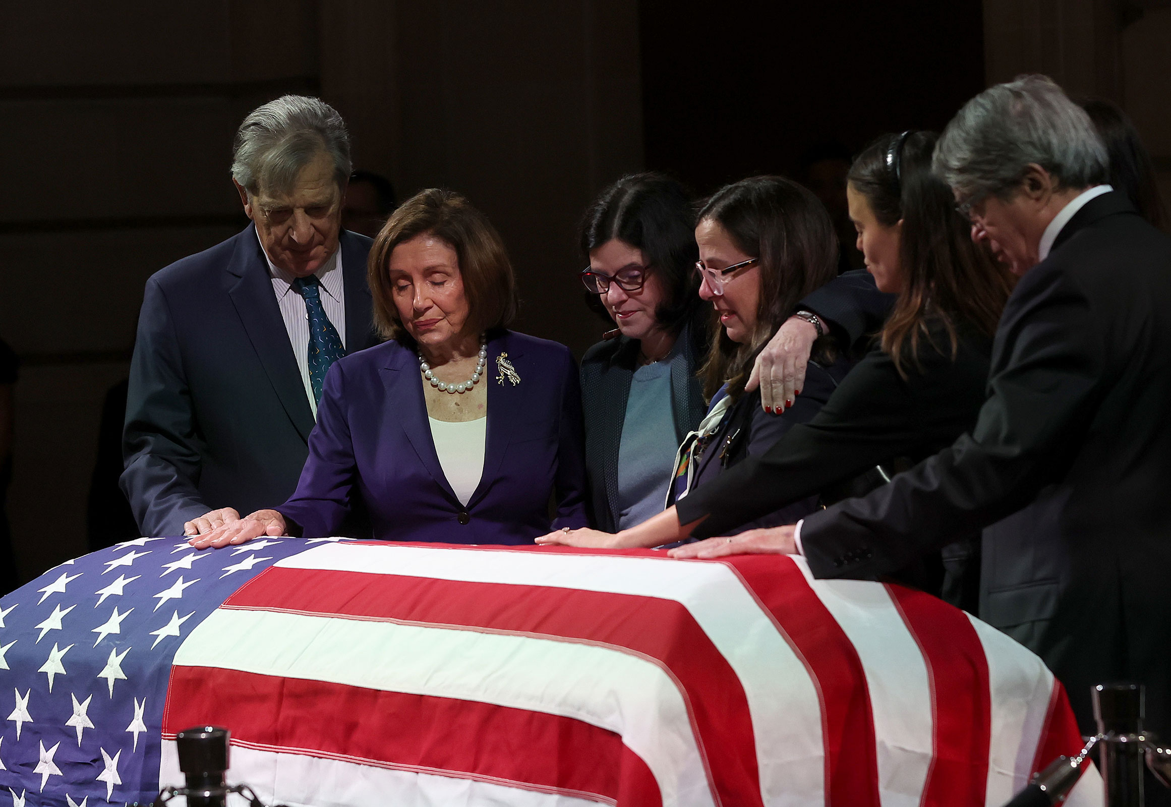 Rep. Nancy Pelosi, surrounded by her family and Feinstein's, stands over the casket of Sen. Dianne Feinstein as she lies in state at San Francisco City Hall on Wednesday. 