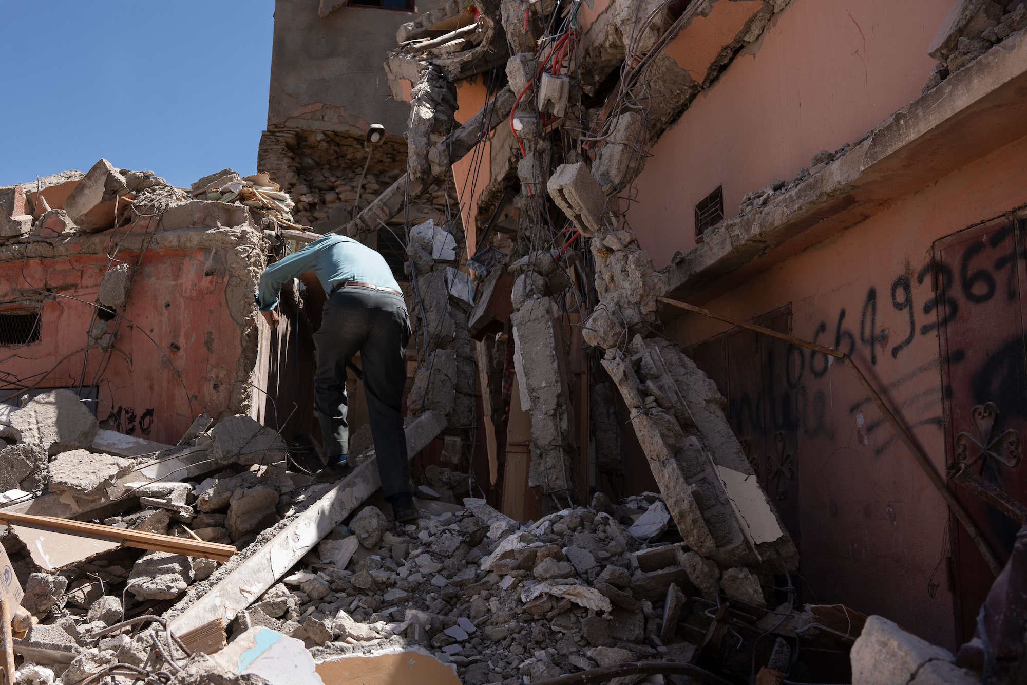 A man enters his house destroyed by the earthquake in the city of Azizmiz on Sunday.