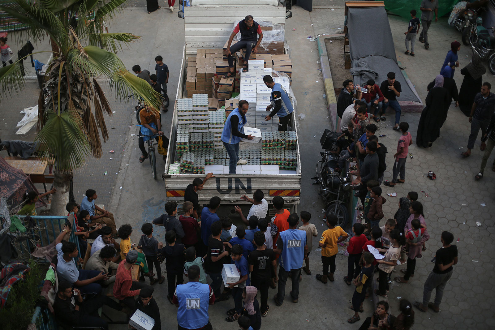 Employees with UNRWA distribute aid to displaced Palestinians at a school in Khan Younis, Gaza, on October 16.