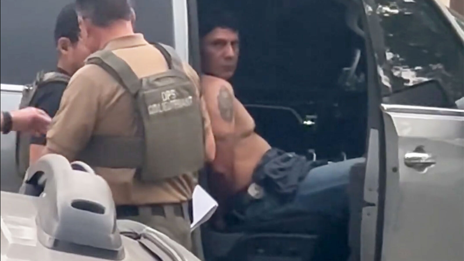 Francisco Oropesa sits in a law enforcement vehicle after being taken into custody Tuesday evening in this screengrab from video taken by a witness.