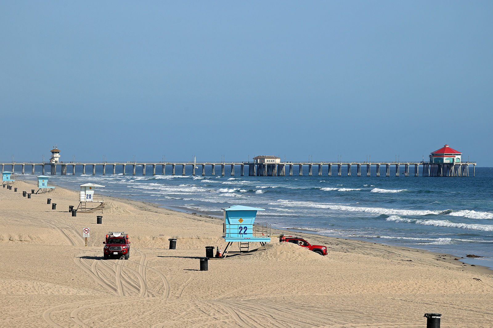 Lifeguards patrol an empty beach in front of the Huntington Beach Pier on Sunday, May 3, in Huntington Beach, California.
