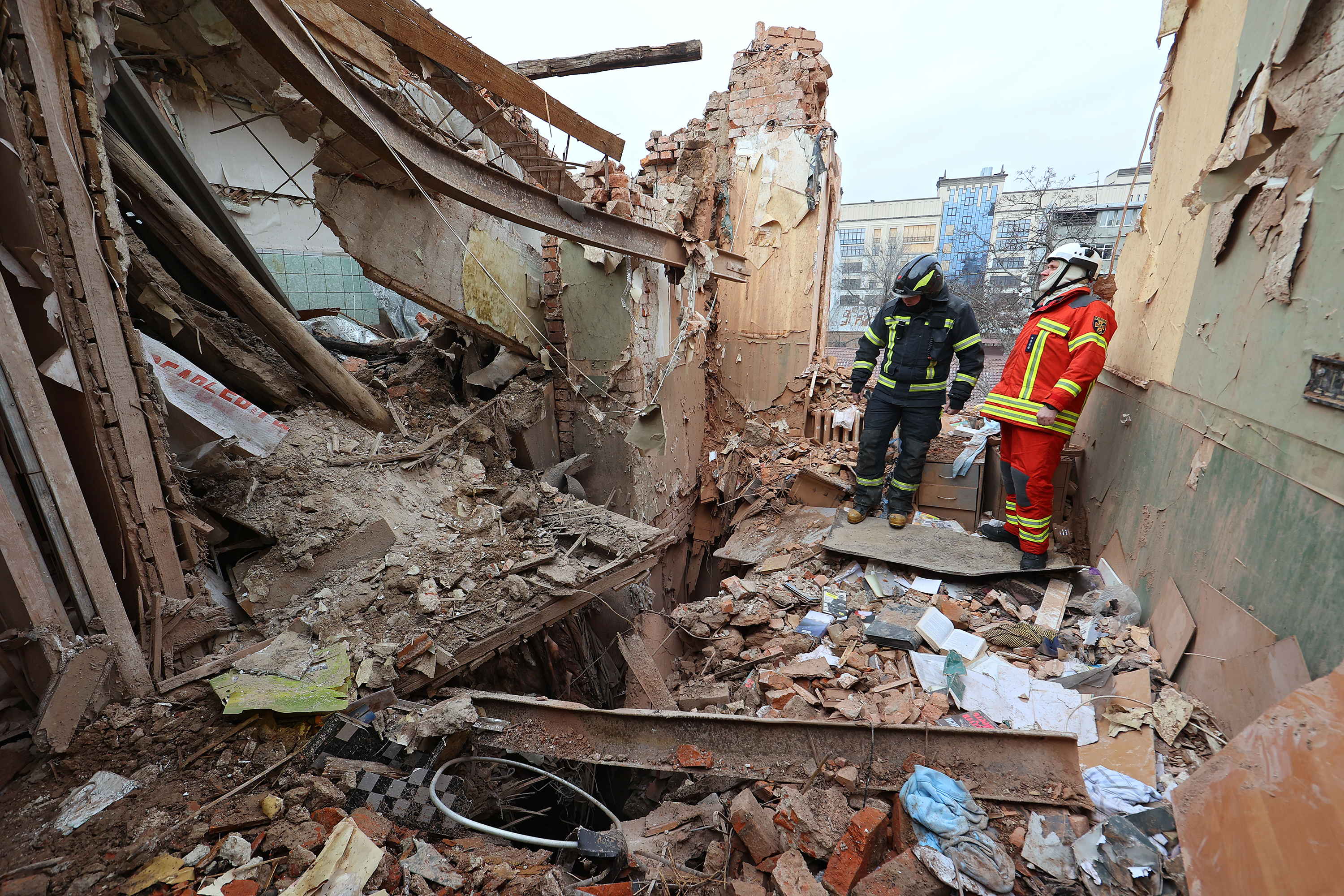 Rescue workers survey a residential building hit by a missile on January 29, in Kharkiv, Ukraine. 