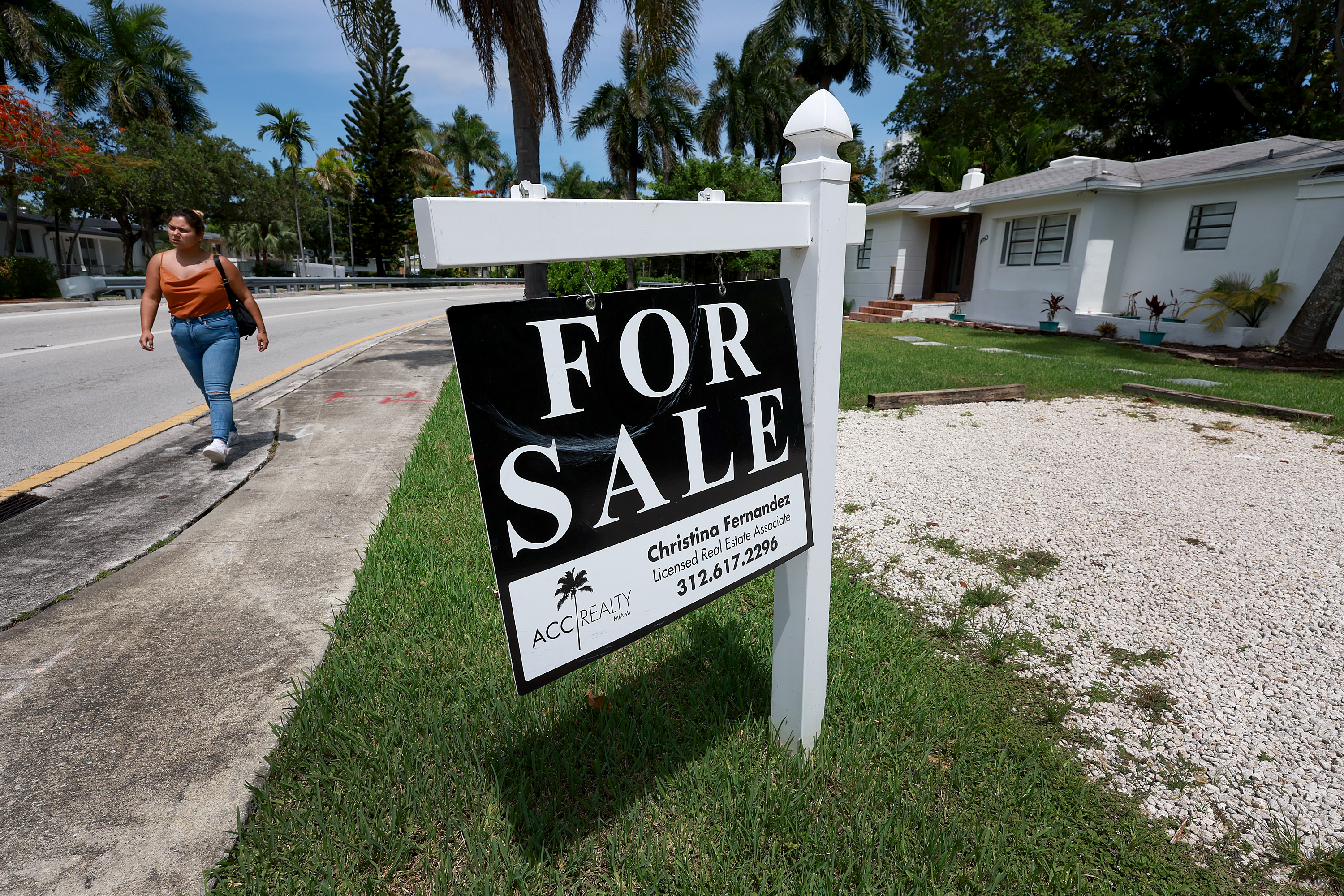A 'for sale' sign hangs in front of a home on June 21 in Miami, Florida.