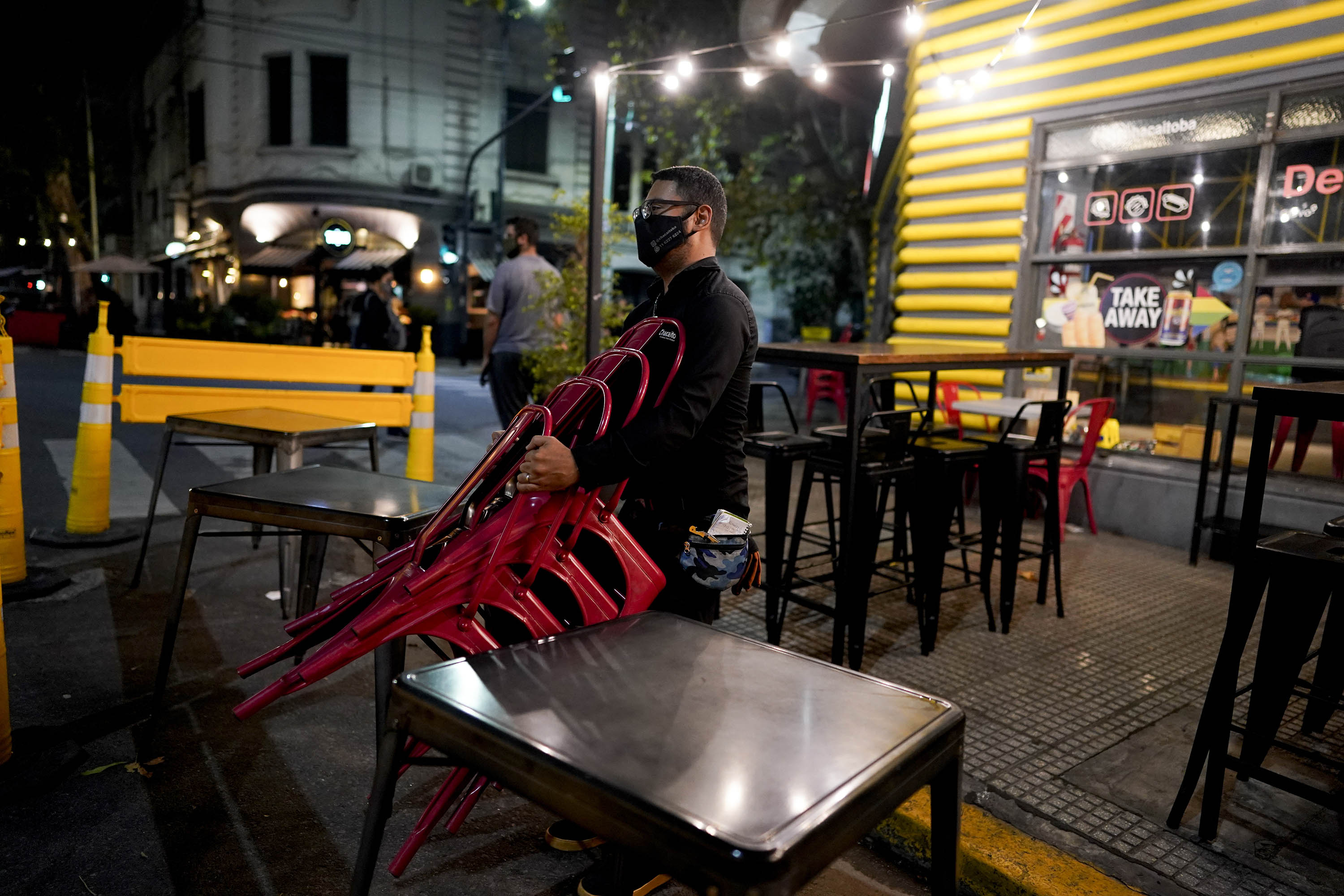 A worker puts away chairs as he closes a bar in Buenos Aires, Argentina, amid Covid-19 restrictions, on April 16. 