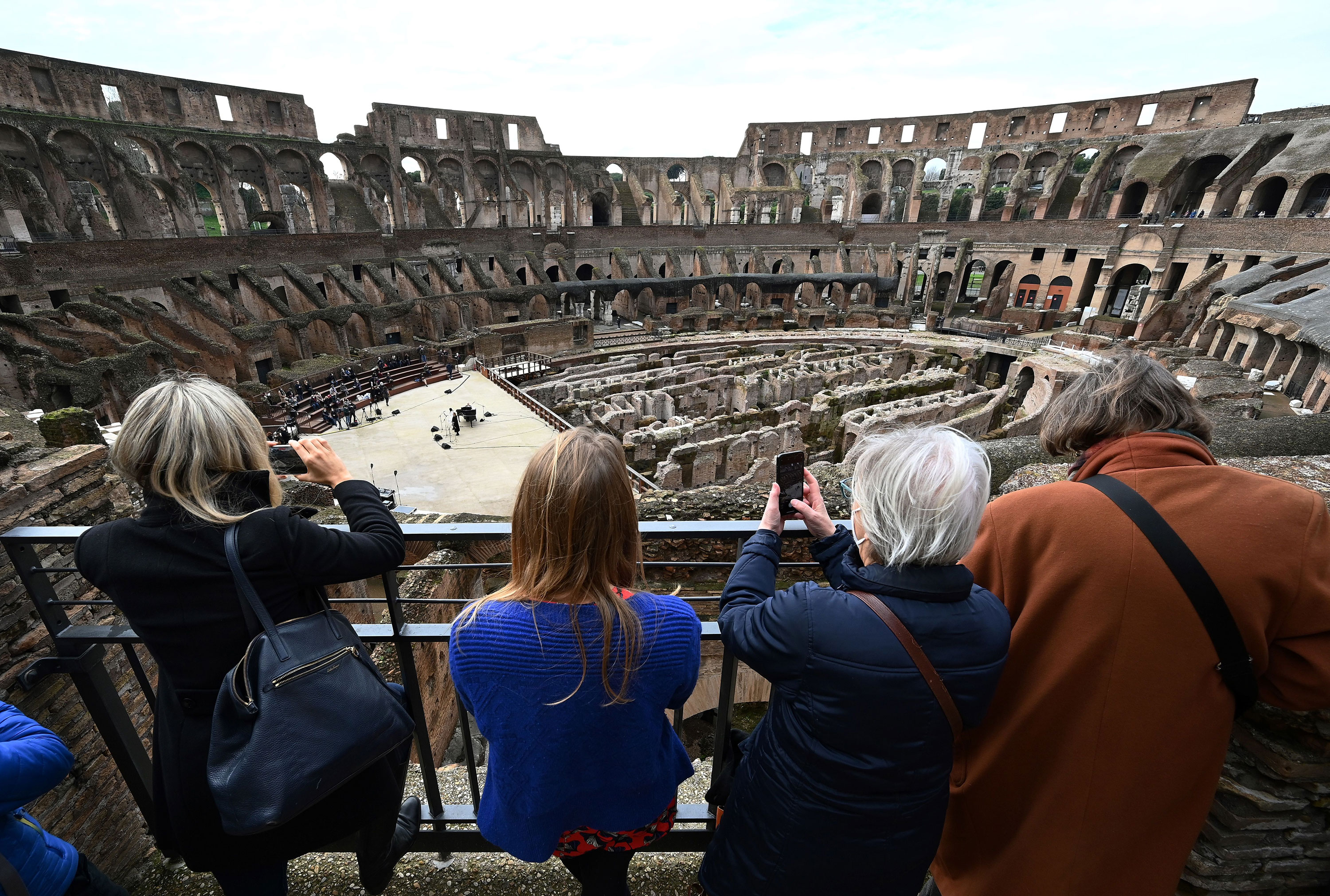 Visitors take pictures as singers and musicians perform at Rome's landmark Colosseum as it reopens amid an easing of coronavirus restrictions on February 1.