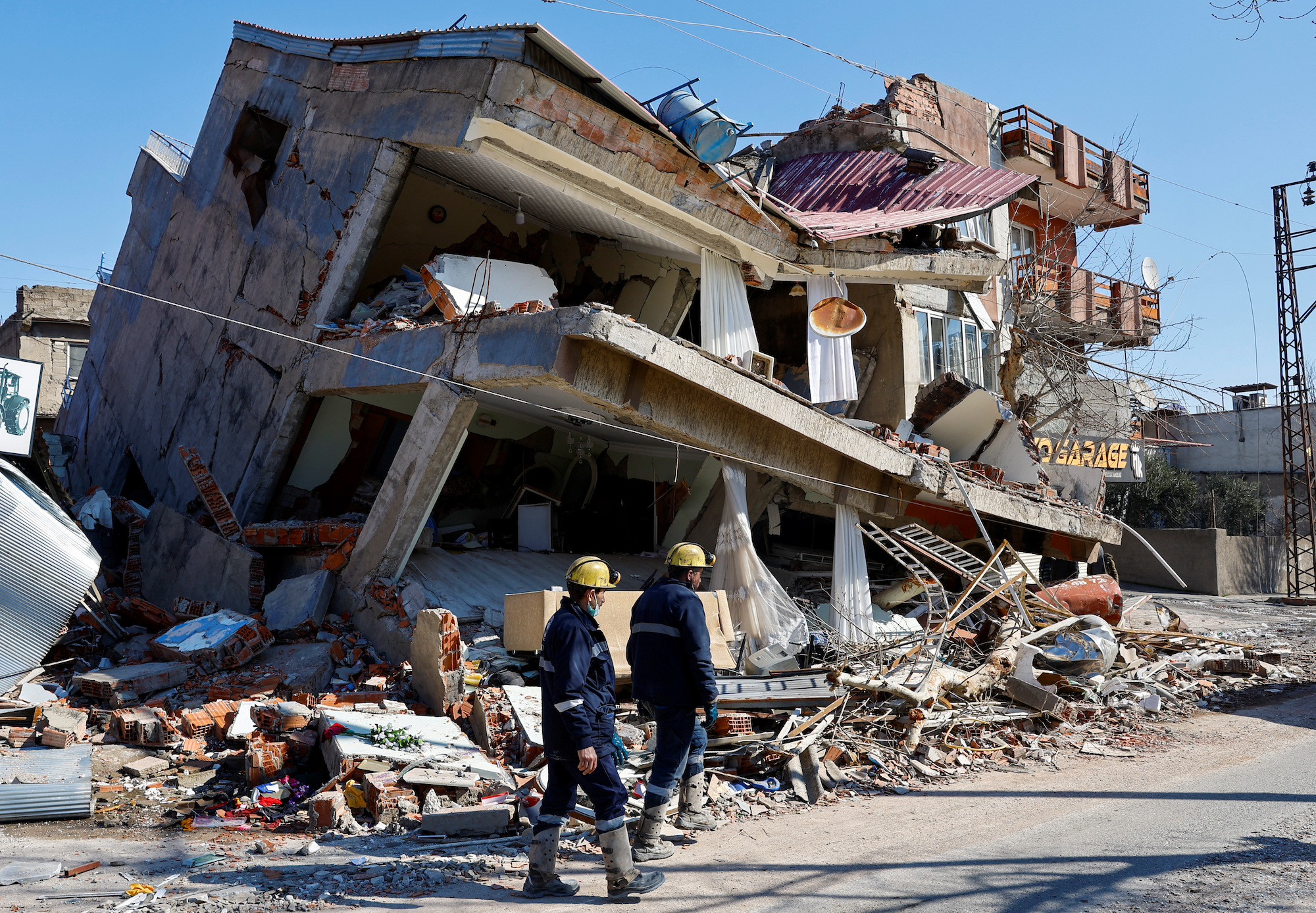 Rescuers walk near a damaged building in Kahramanmaras, Turkey, on Thursday.
