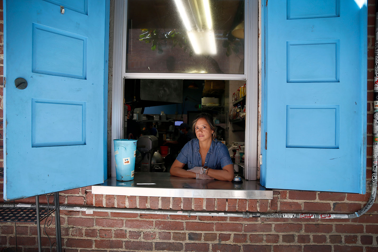 Deanna Sison stands at the window where she takes to-go orders at her restaurant in San Francisco, California.