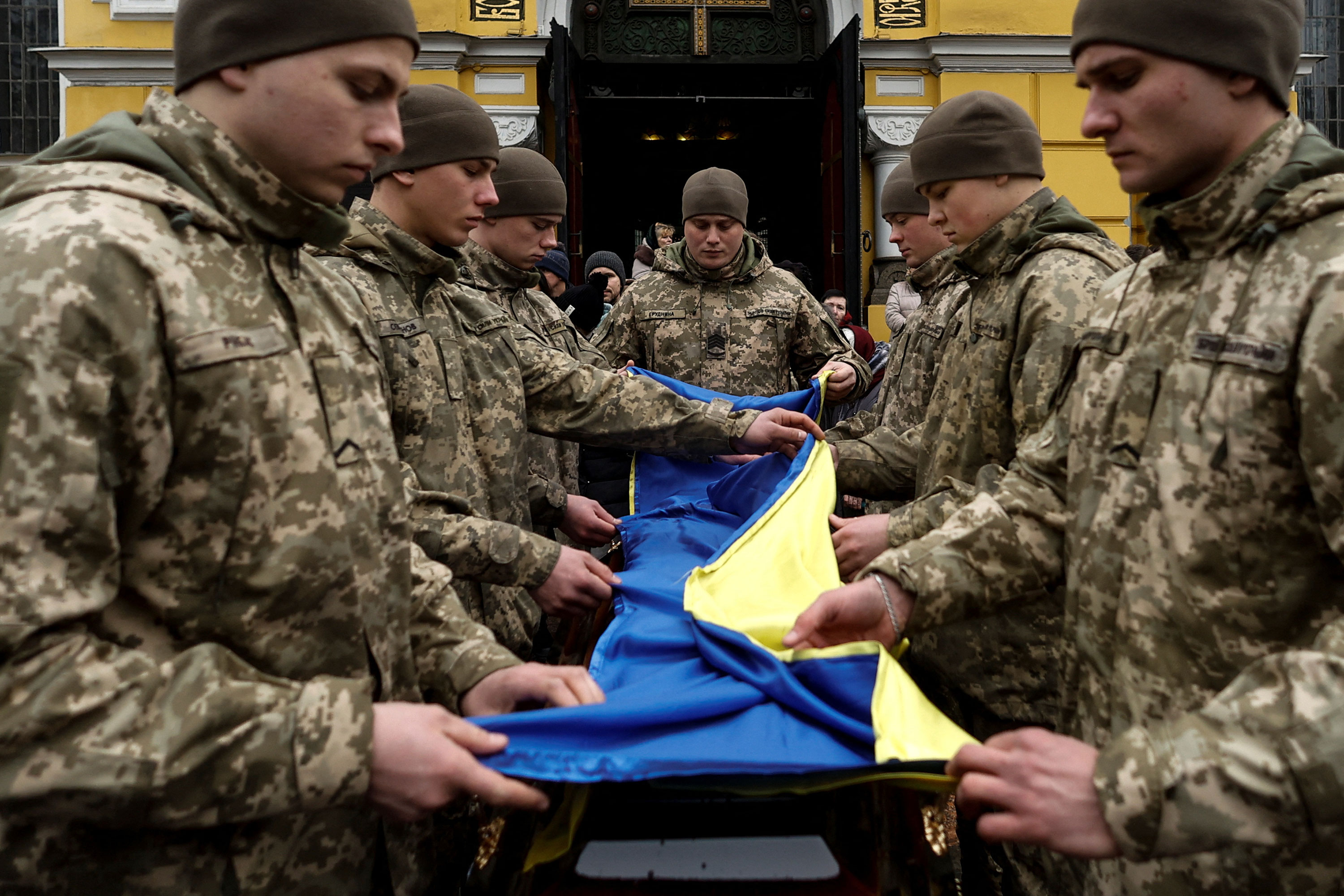 Members of the Honour Guard fold a national flag in Kyiv, Ukraine, on Tuesday over a coffin with the body of a Ukrainian serviceman killed near Bakhmut.