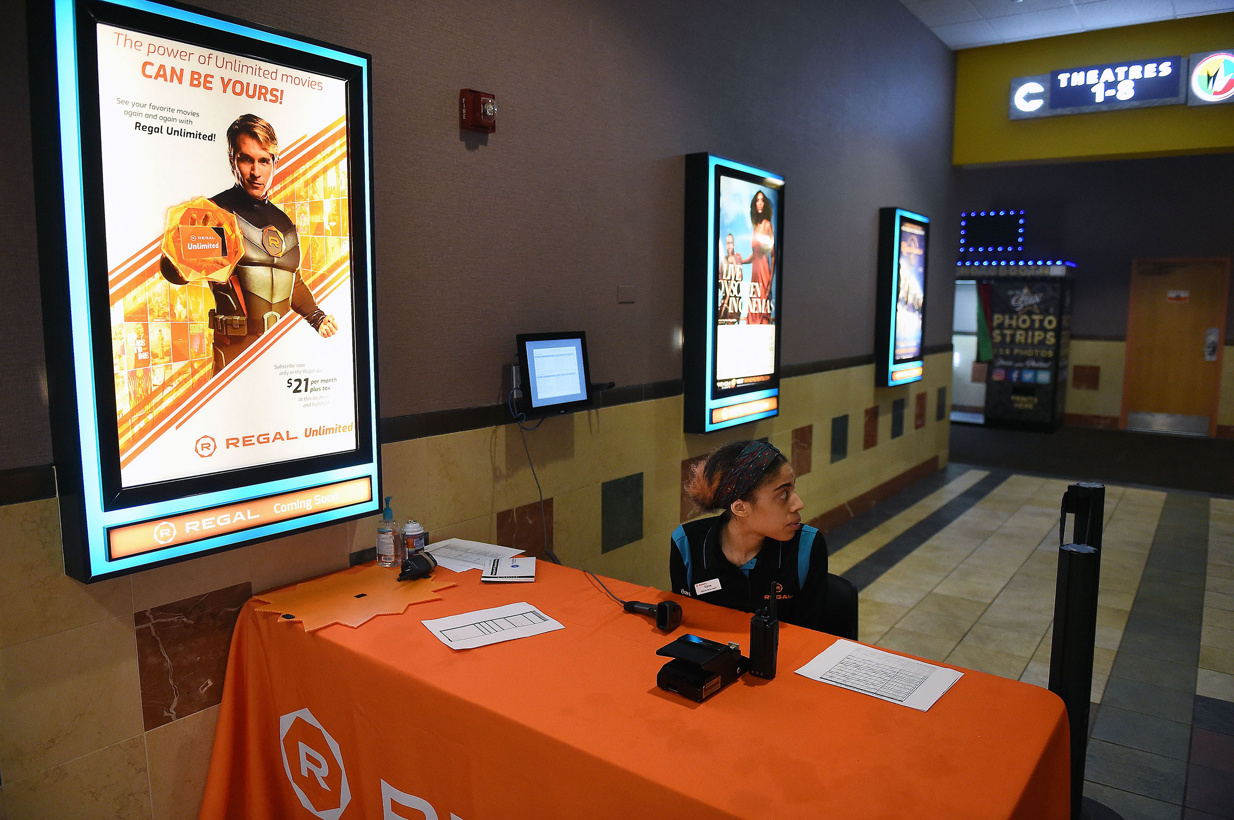 An employee waits at an empty Regal Cinemas movie theatre in Washington, DC, on March 15.