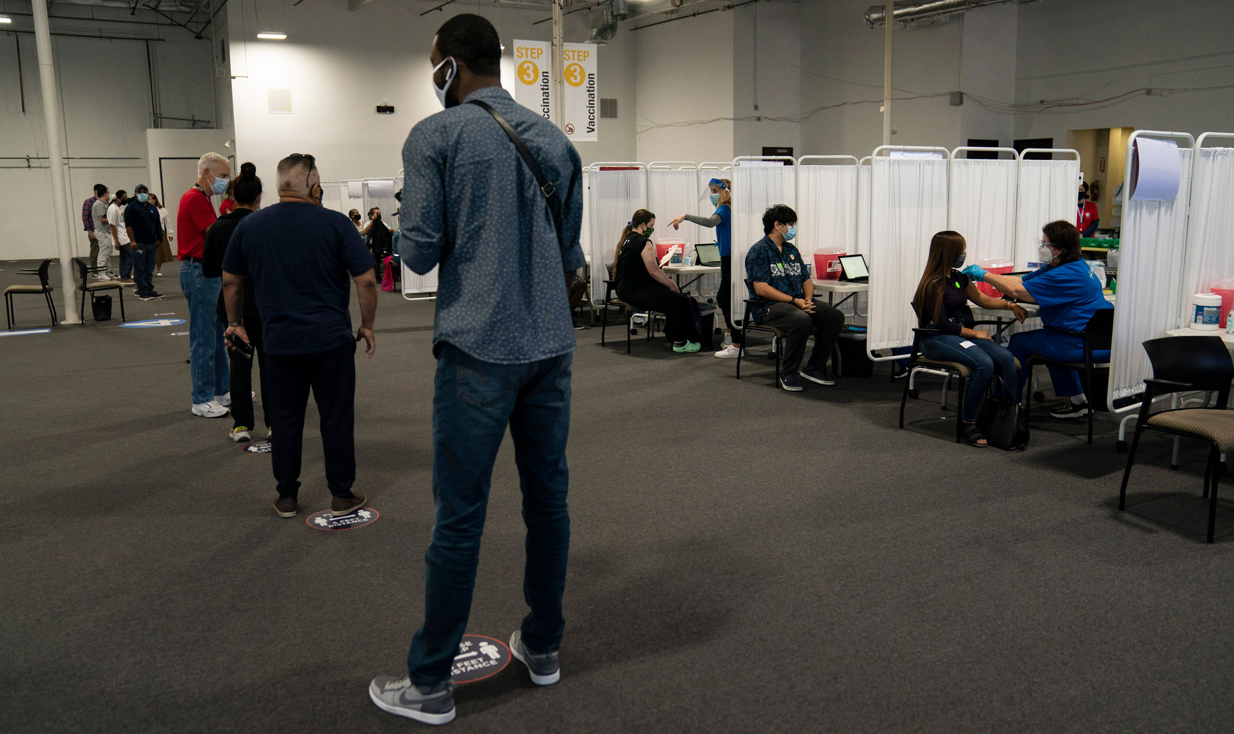People wait to receive a Covid-19 vaccine in Santa Ana, California, on Friday.
