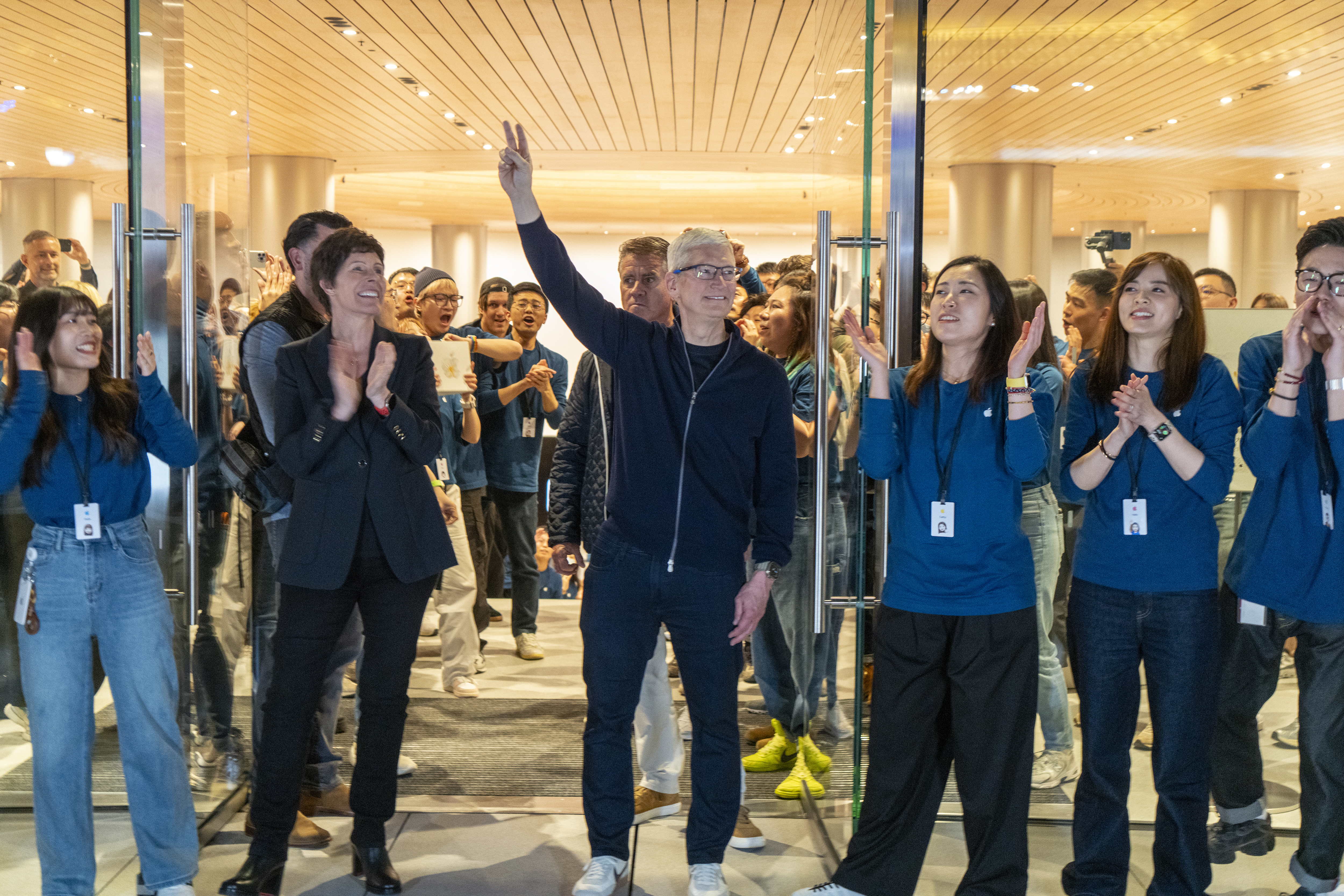 Apple CEO Tim Cook, center, and Deirdre O'Brien, senior vice president of retail for Apple, left, attend the opening of the company’s new store in Shanghai, China, on March 21.