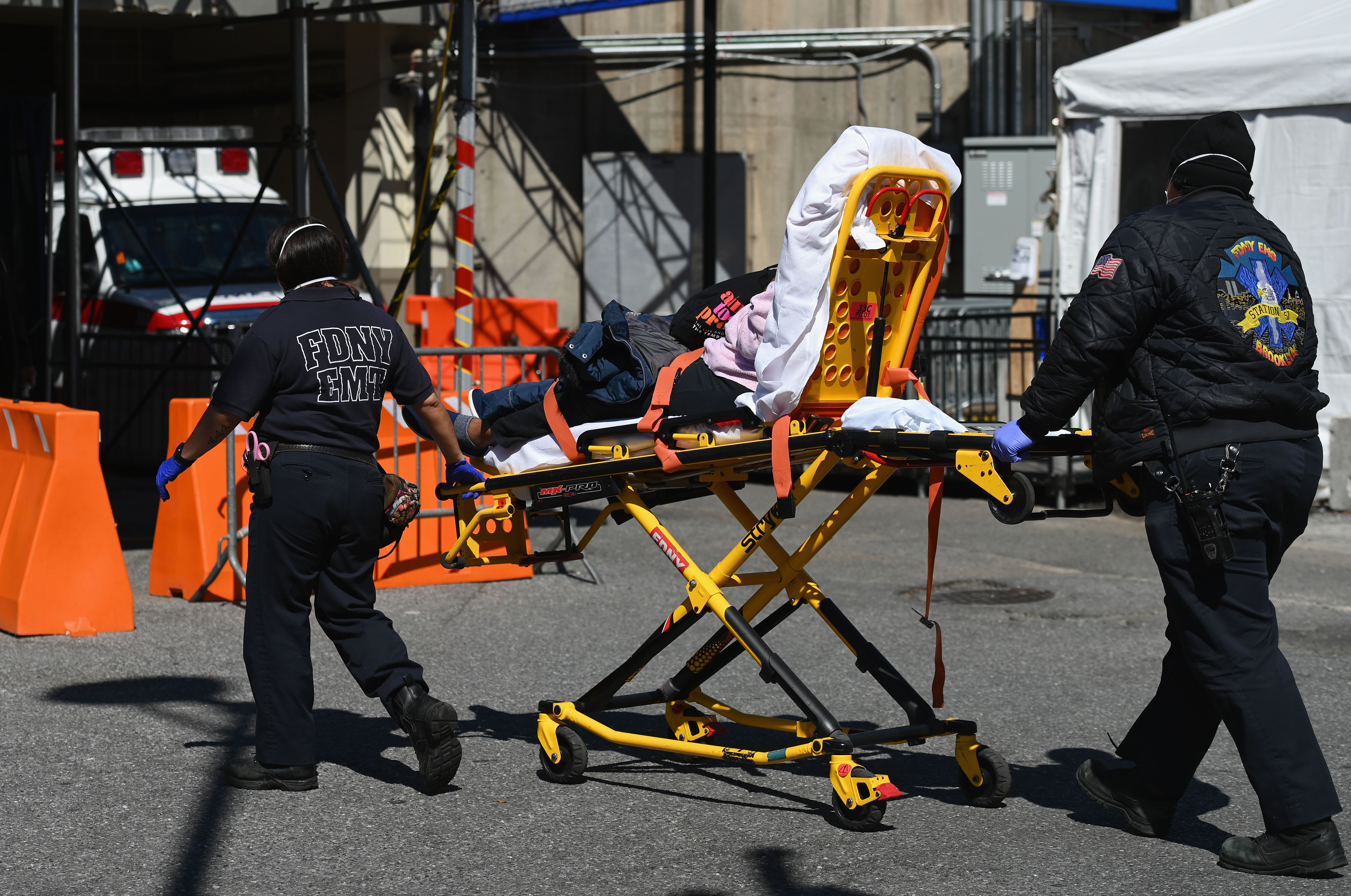 Paramedics roll a stretcher with a patient to the Brooklyn Hospital Center emergency room on Friday, March 27.