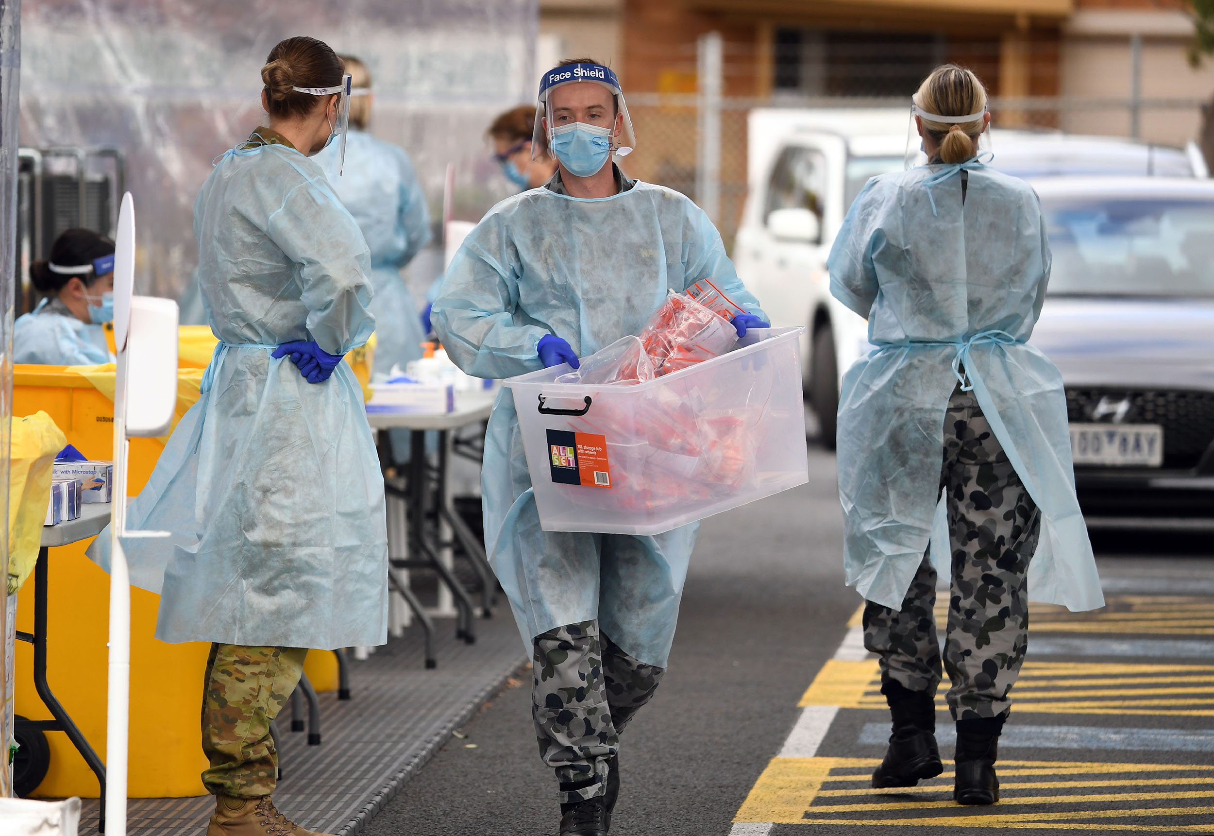 A member of the Australian Defence Force carries a batch of swab samples taken from members of the public at a drive-through coronavirus testing station in the Melbourne suburb of Fawkner on July 2.