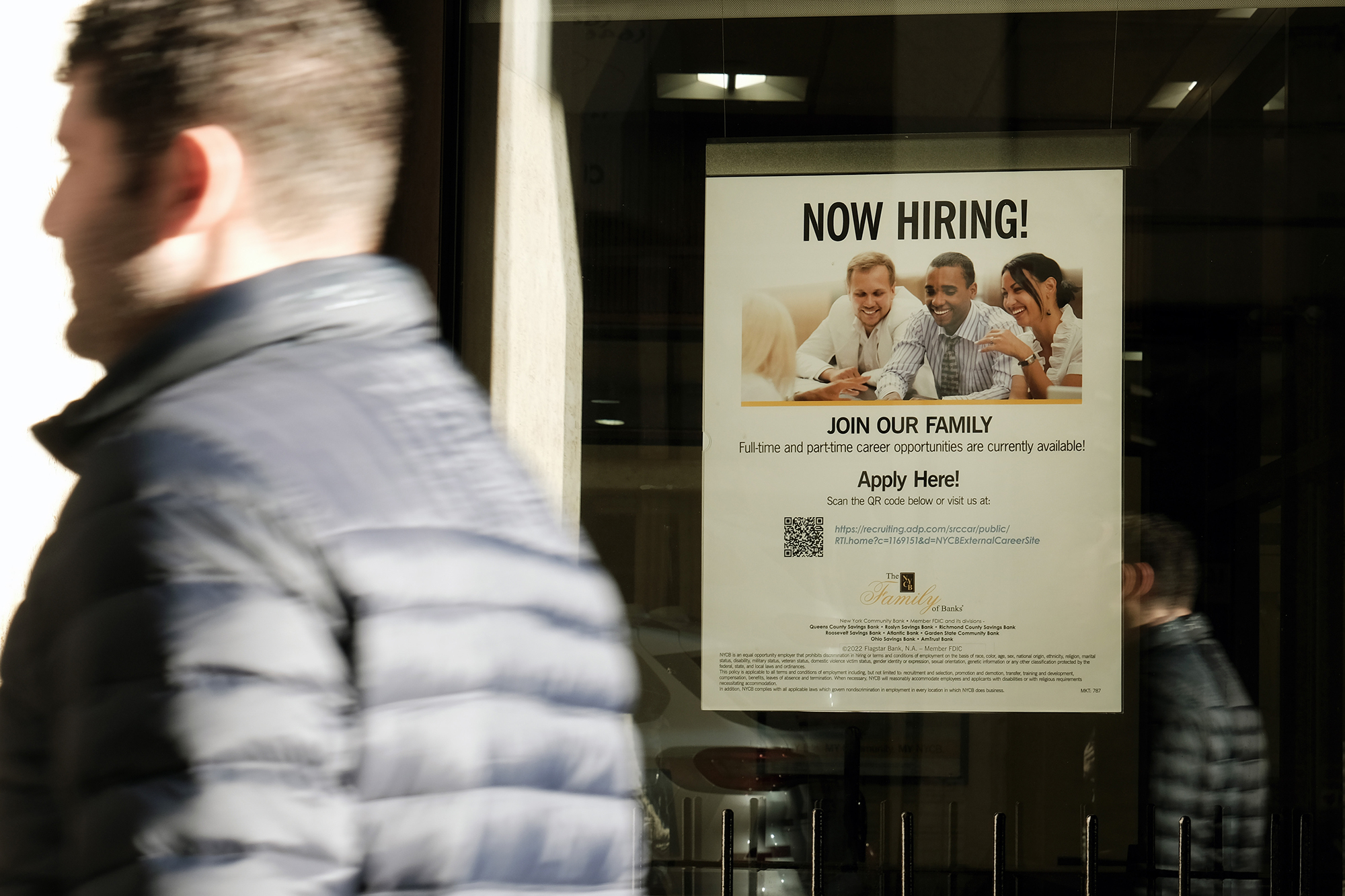 A 'now hiring' sign is displayed in a window of a store in Manhattan on December 2, 2022 in New York City. 