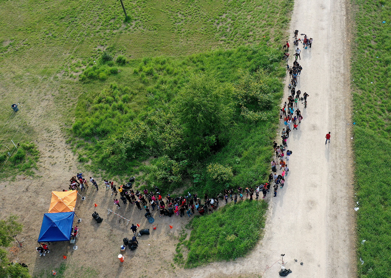 In this aerial view, migrants stand in line as they wait to be processed by the US Border Patrol in Brownsville, Texas, on May 10.