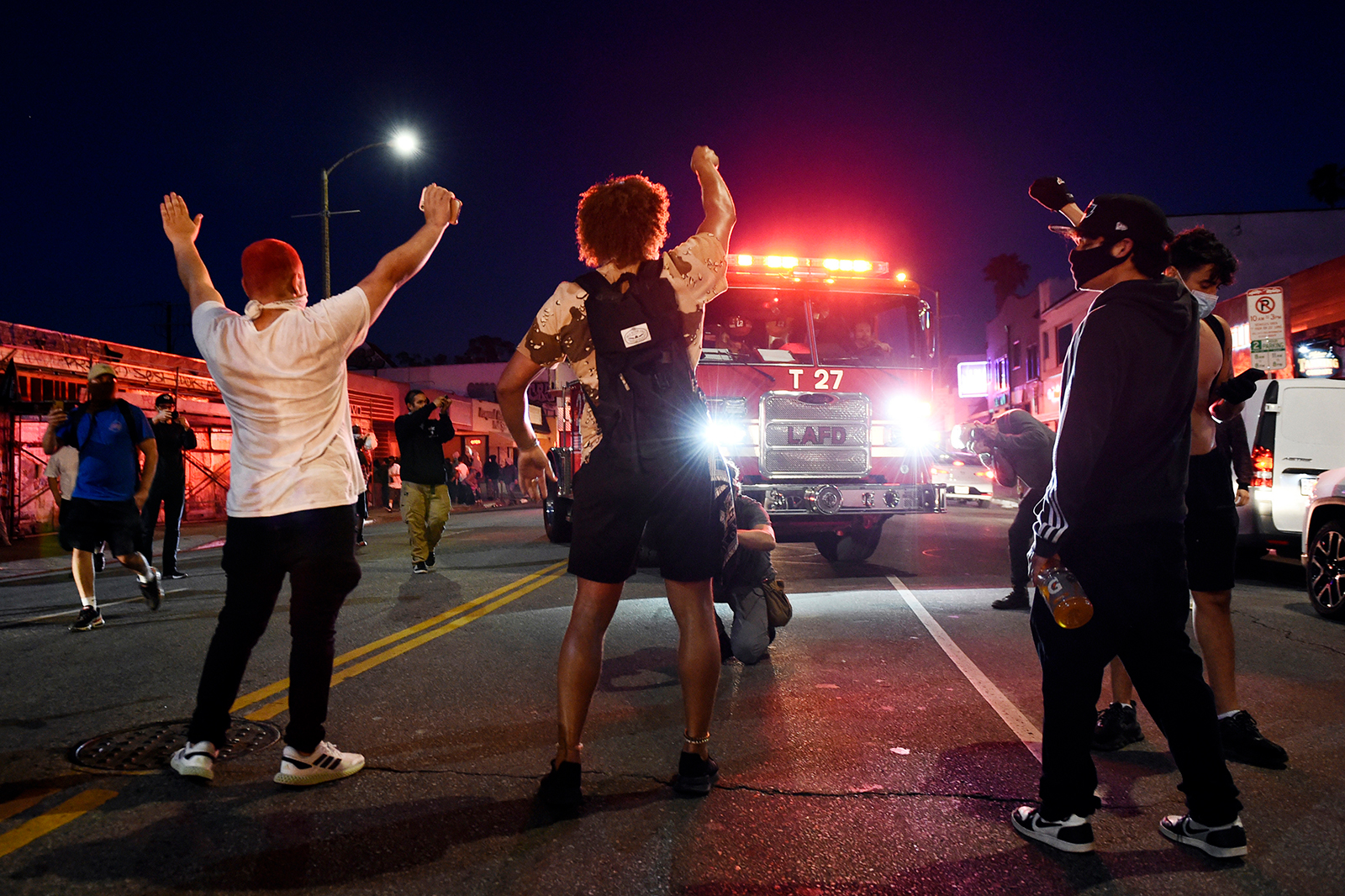 Demonstrators block the path of a Los Angeles Fire Department truck on Melrose Avenue, on Saturday, May 30, in Los Angeles.