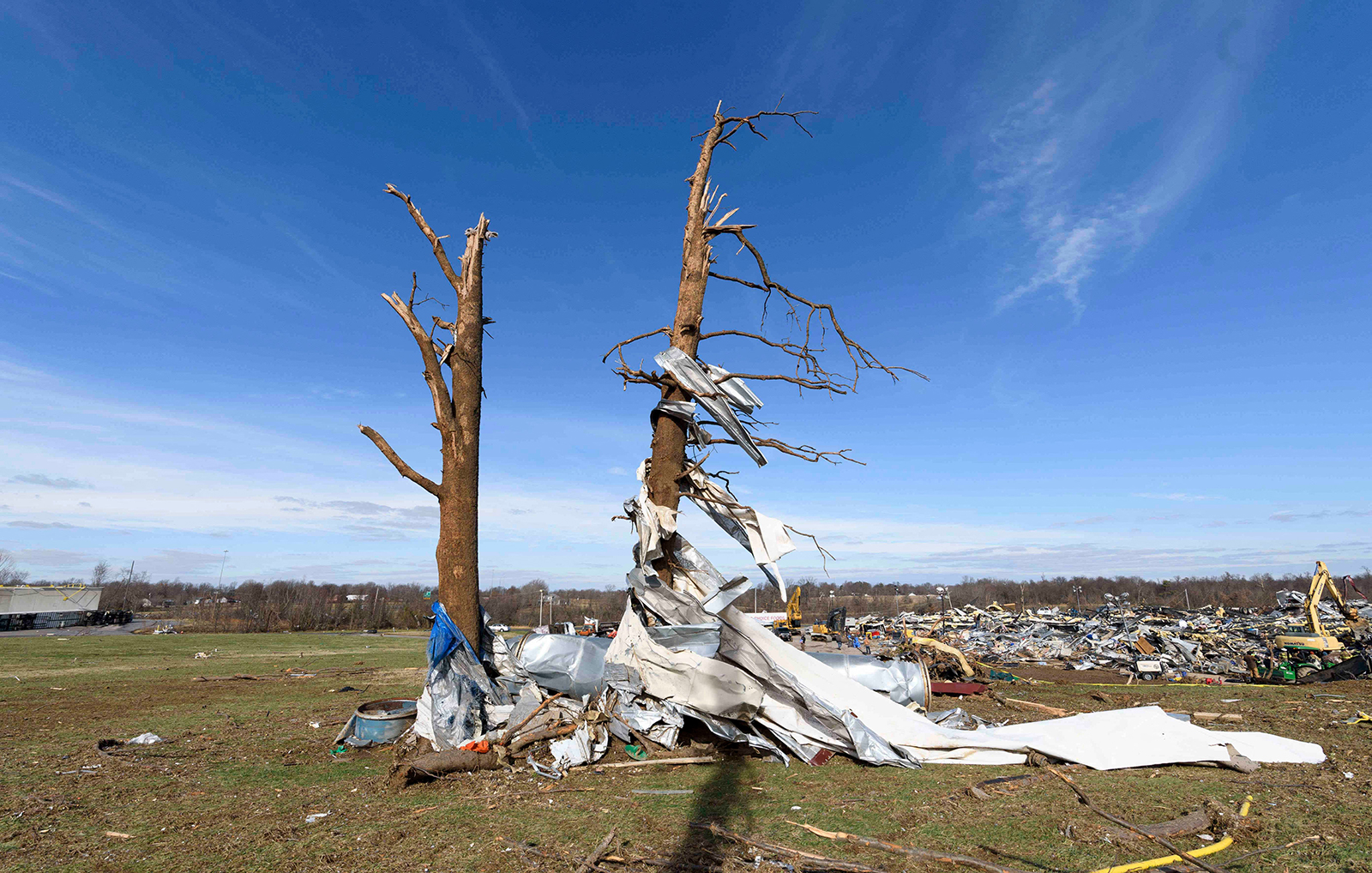 Debris is wrapped around damaged trees as emergency workers search through what is left of the Mayfield Consumer Products Candle Factory after it was destroyed by a tornado in Mayfield, Kentucky, on December 11. (John Amis/AFP/Getty Images)