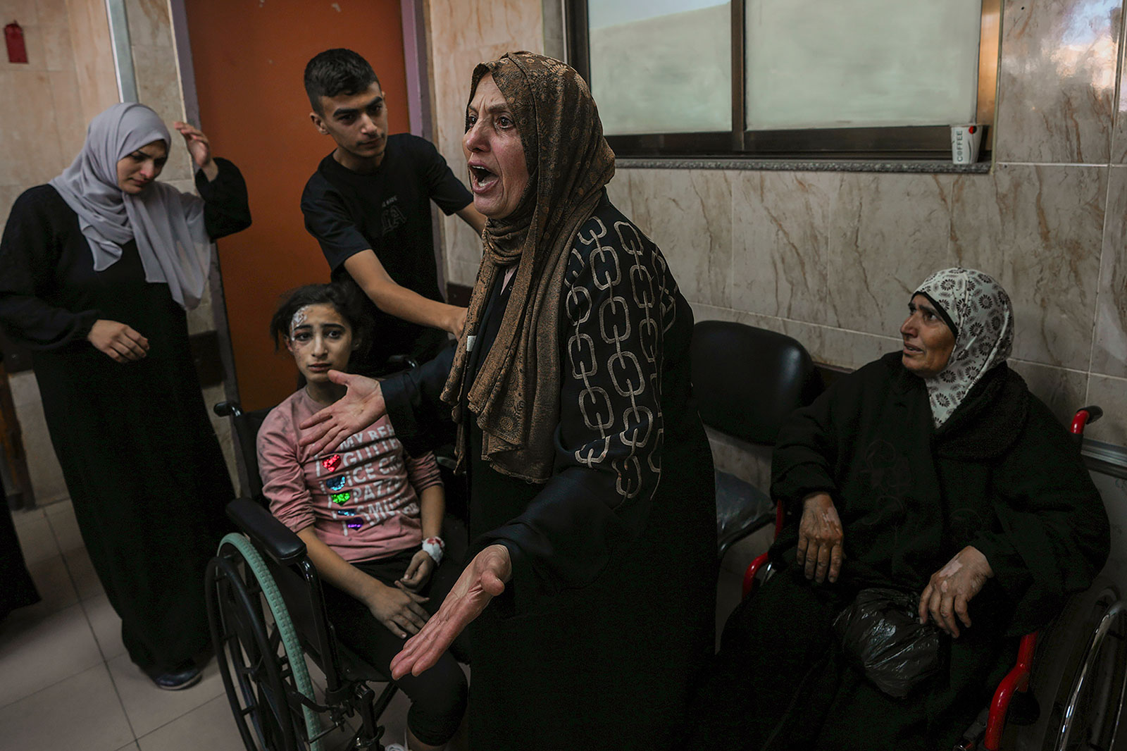 At al-Aqsa hospital in central Gaza  on Sunday, October 15, a Palestinian woman reacts next to people wounded during an Israeli Airstrike. 
