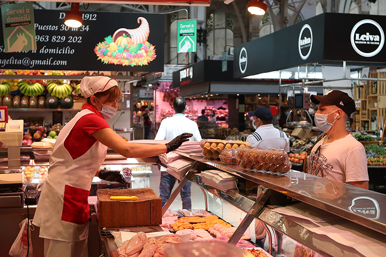 A worker at an egg stall in Valencia's Central Market serves a customer after the Ministry of Health authorized the whole of the Valencian Community to move to phase 1 of the de-escalation on Monday, May 18, in Valencia, Spain. 