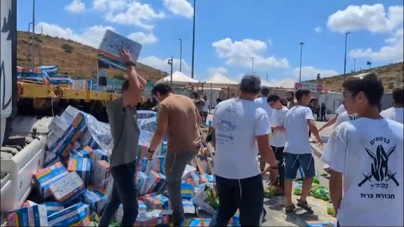A screengrab of a video shows Israeli activists blocking the path of the aid trucks and throwing aid packages on the ground.