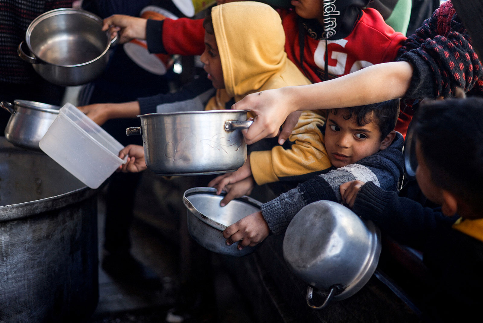 Palestinian children wait to receive food cooked by a charity kitchen in Rafah,Gaza, on Tuesday, March 5. 