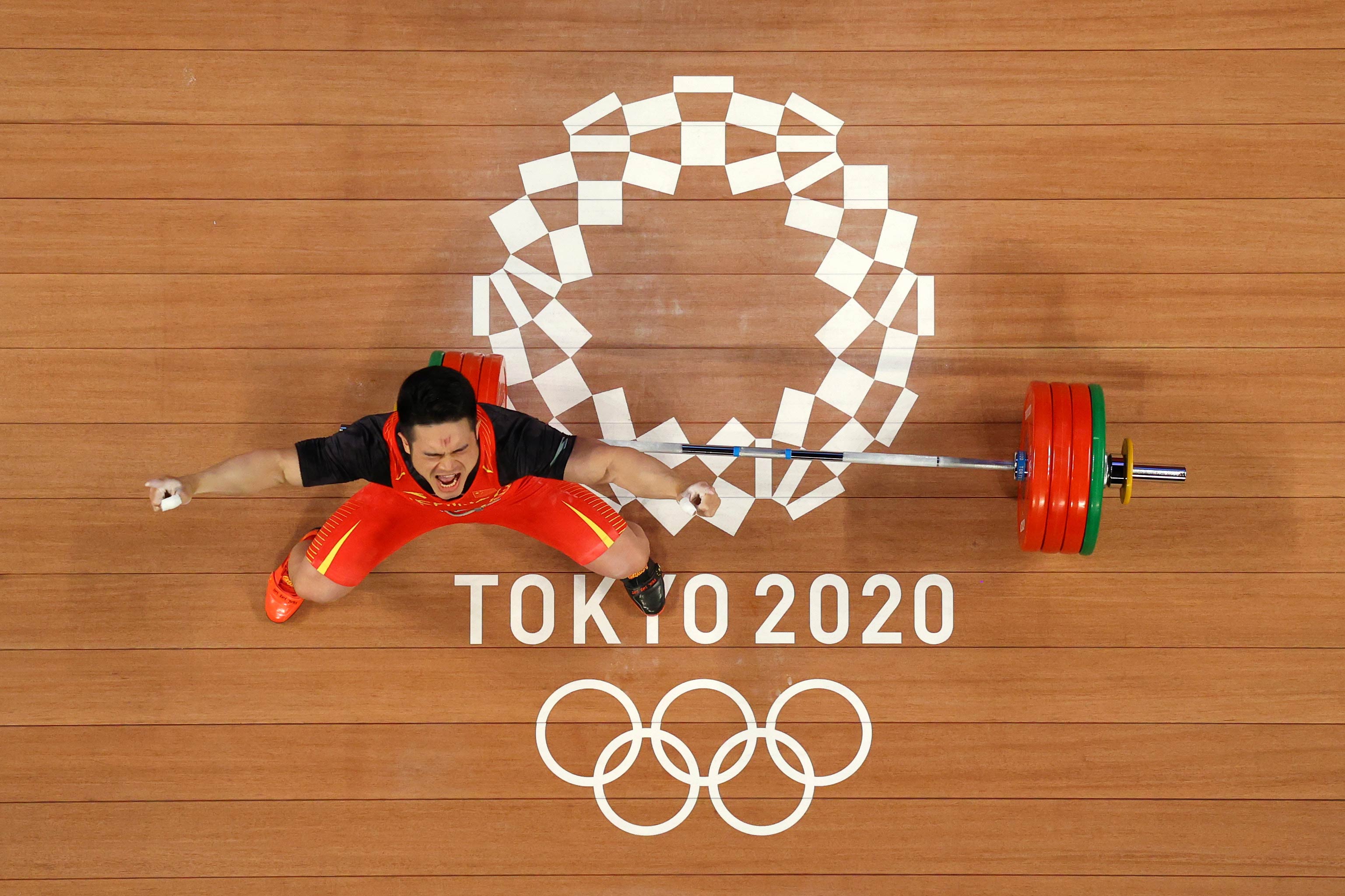 China's Shi Zhiyong celebrates after winning the gold medal and setting a new Olympic record in the 73kg weightlifting event on July 28.