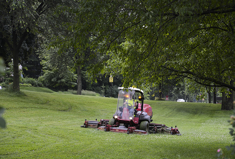 A Minneapolis Park and Recreation Board staff person mowing the grass at Lyndale Park. 