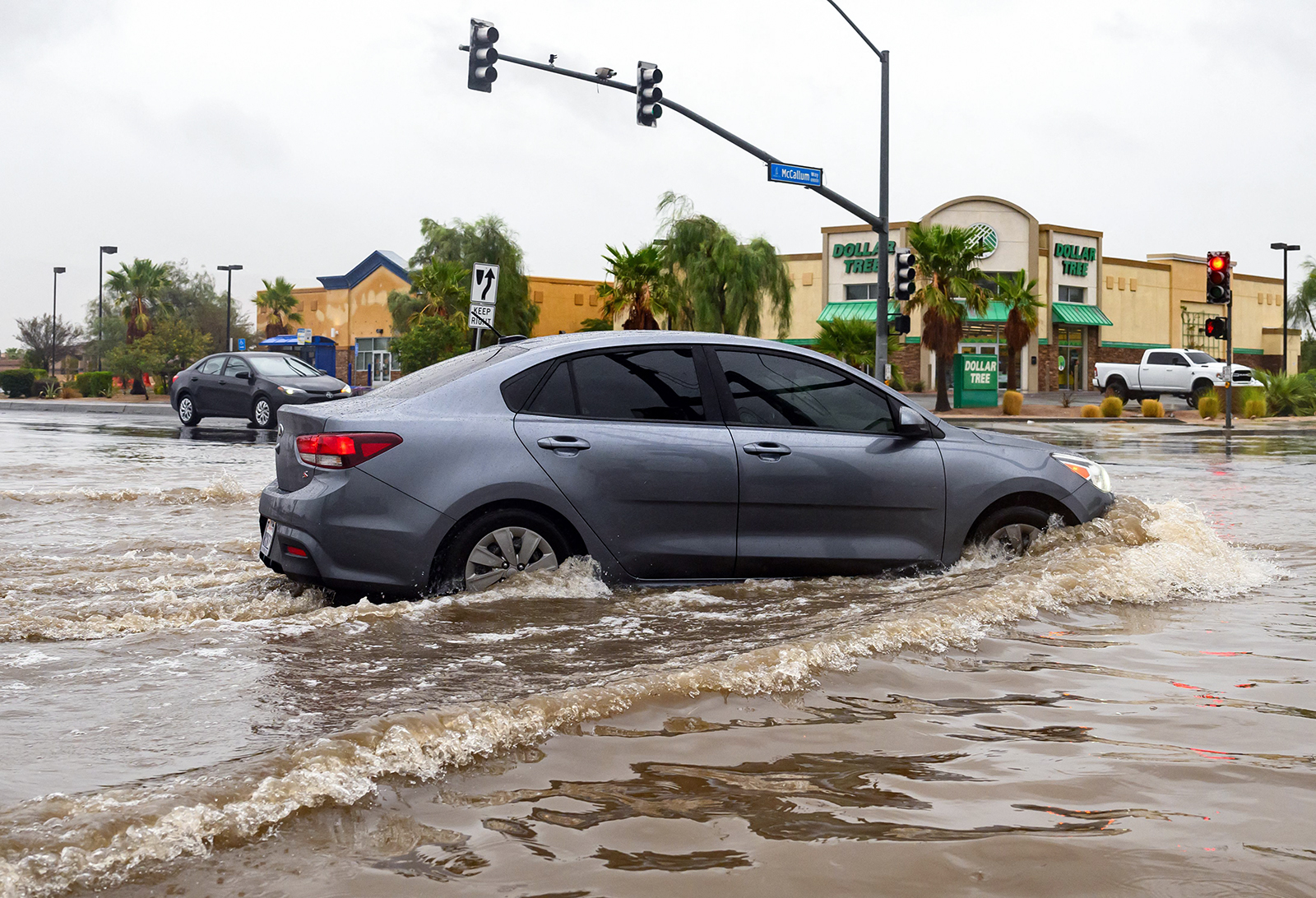 Tropical Storm Hilary 20 Ağustos'ta California, Palm Springs'te karaya inerken bir araç su basmış bir kavşaktan geçiyor.