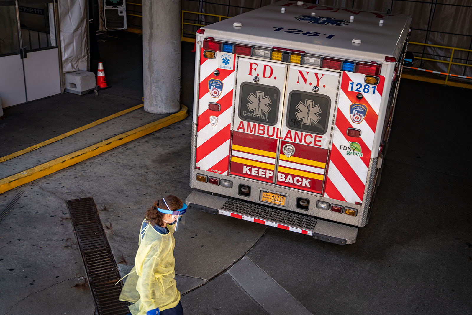A medical worker walks by a New York Fire Department ambulance parked outside Montefiore Medical Center in New York on Thursday, April 2.