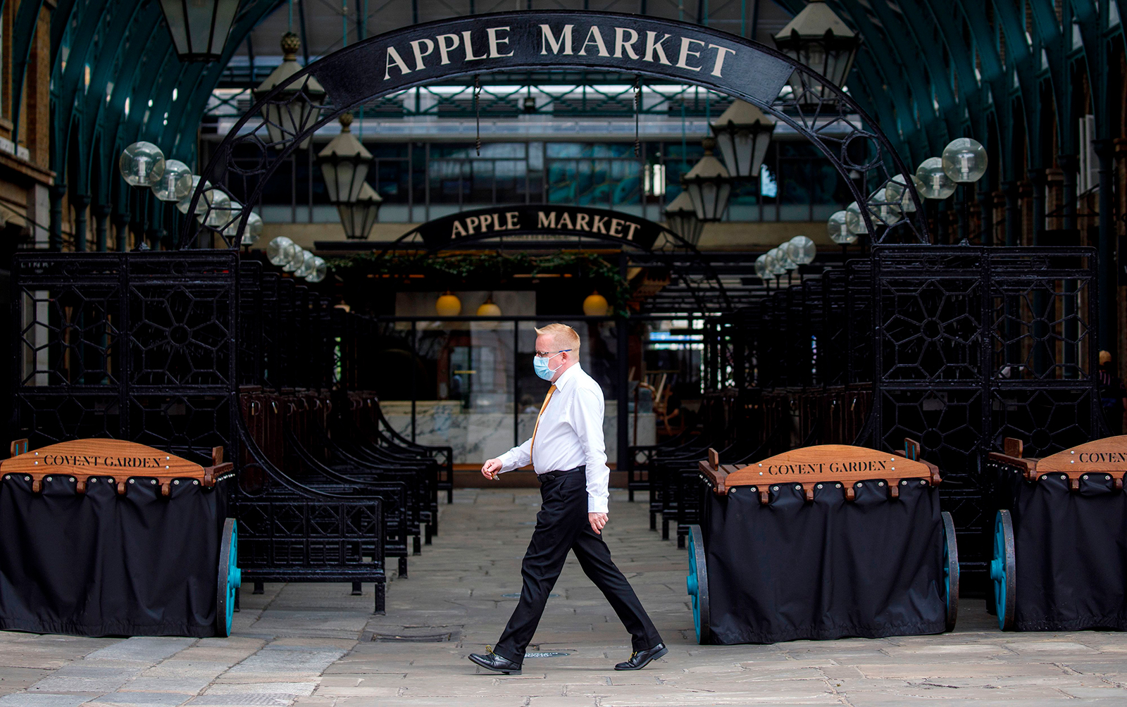 A man wearing a face mask walks in an empty Covent Garden in London on June 15.