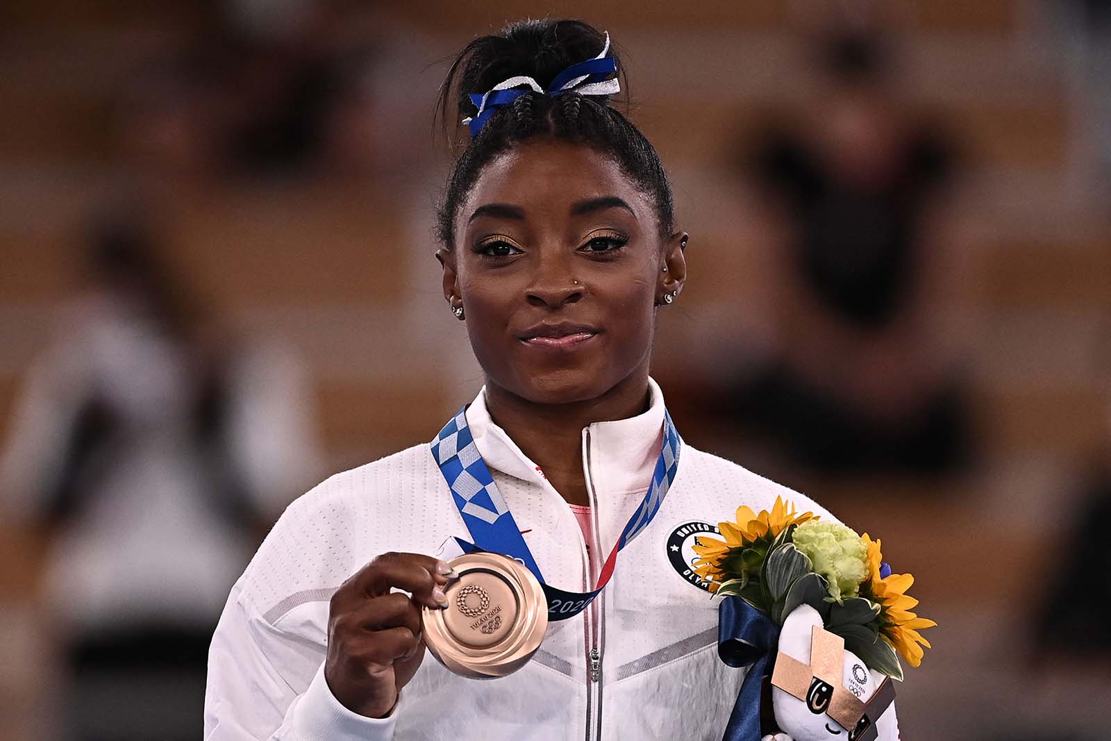 Simone Biles poses with her bronze medal during the podium ceremony for the artistic gymnastics women's balance beam event on Tuesday. 