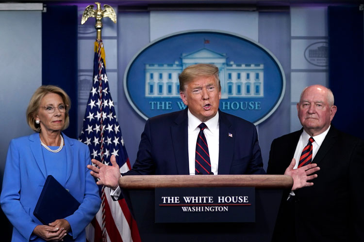 U.S. President Donald Trump, Secretary of Education Betsy DeVos, left, and Secretary of Agriculture Sonny Perdue, right, participate in a briefing on the coronavirus pandemic at the White House on March 27, in Washington, DC. 