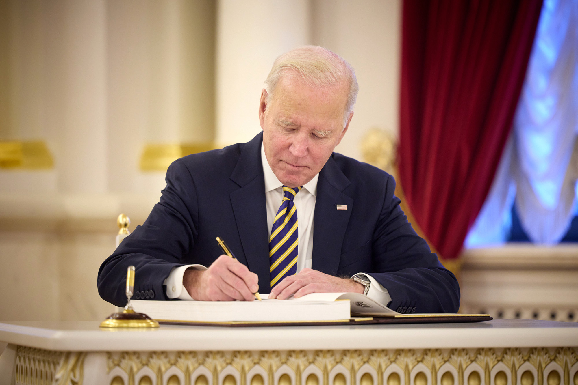U.S. President Joe Biden signs the guest book during a meeting with Ukrainian President Volodymyr Zelensky at the Ukrainian presidential palace on February 20, in Kyiv, Ukraine. 