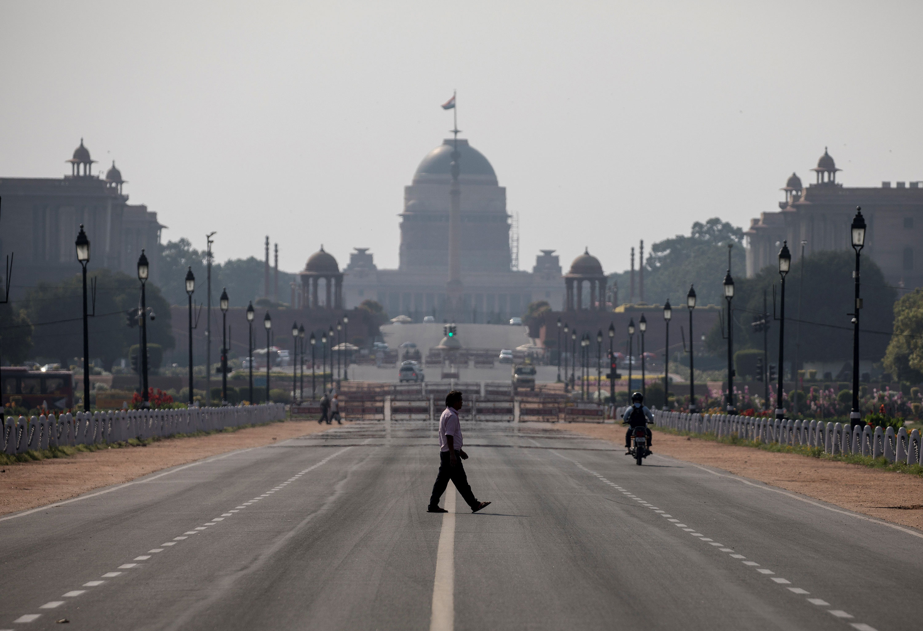 A man crosses a nearly empty Rajpath in New Delhi on March 22.