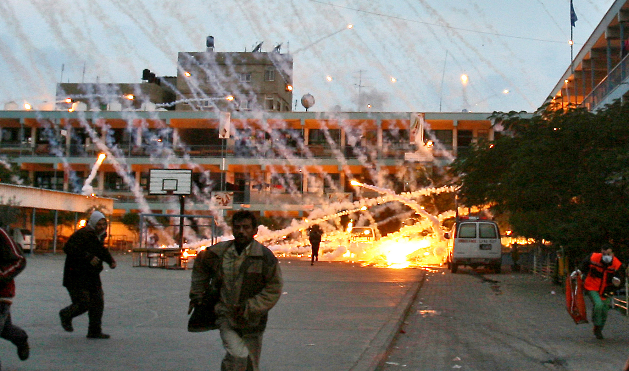 Palestinian civilians and medics run to safety during an Israeli strike over a UN school in Beit Lahia, northern Gaza, on January 17, 2009.