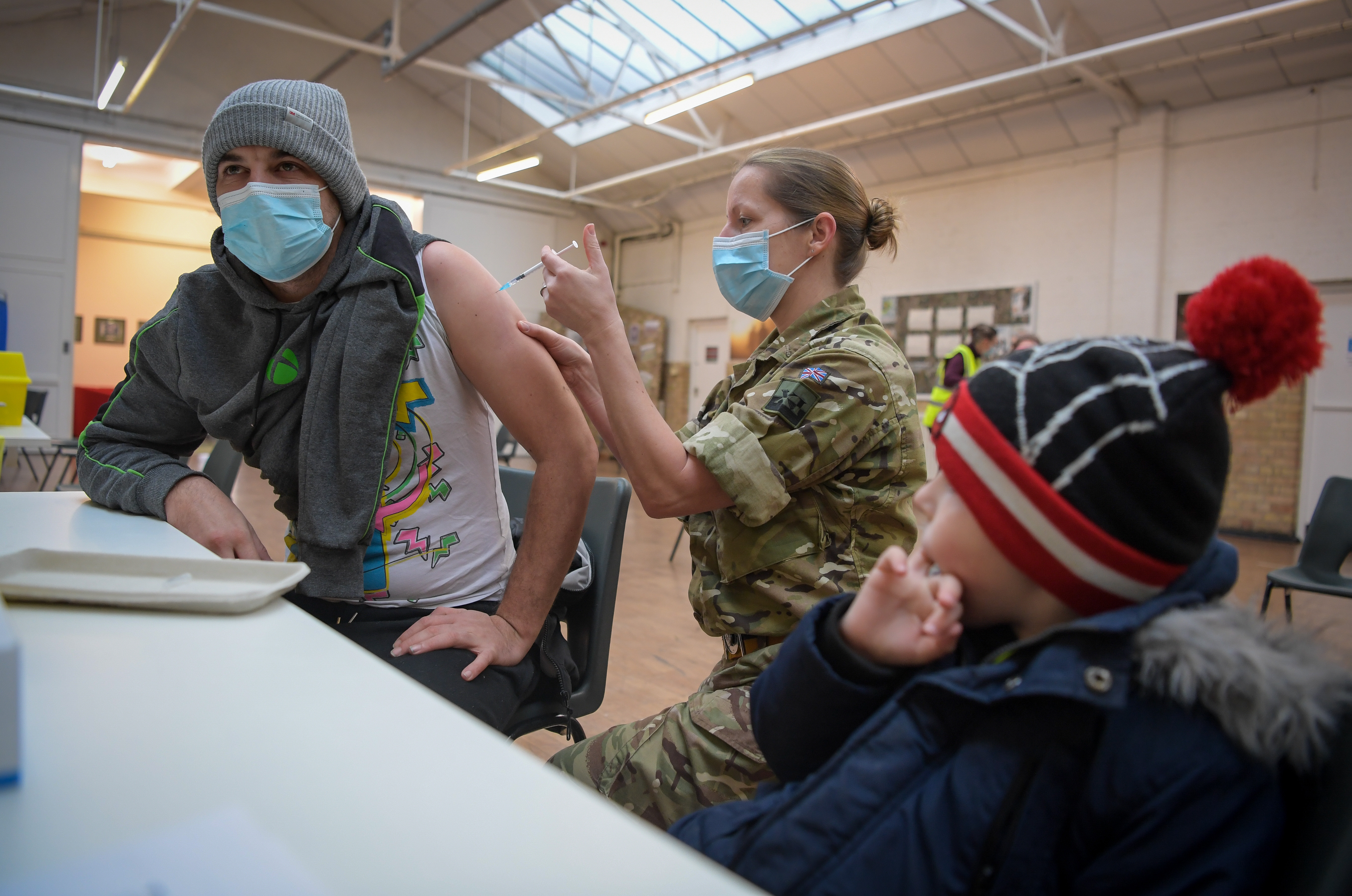 Lt Col Alex Wolfenden of Royal Army Medical Corps administers a vaccination at the Army Reserve Centre on December 23, 2021 in Poole, England.