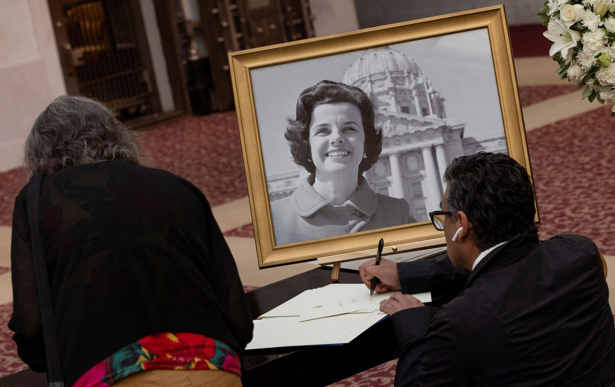 A man signs a condolence book for Feinstein's family at San Francisco's City Hall on Wednesday.