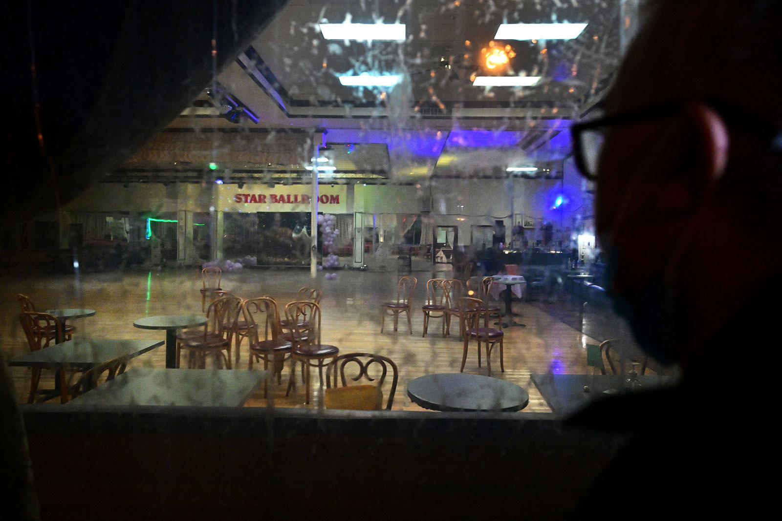 A man takes a closer look through the glass at the interior of the Star Ballroom Dance Studio in Monterey Park Monday evening.