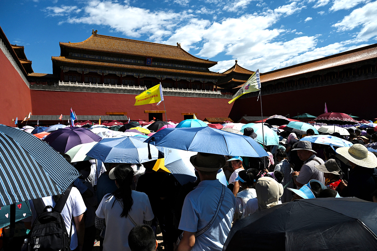 Visitors shelter under umbrellas as they line up to enter the Forbidden City on a hot day in Beijing on July 9.