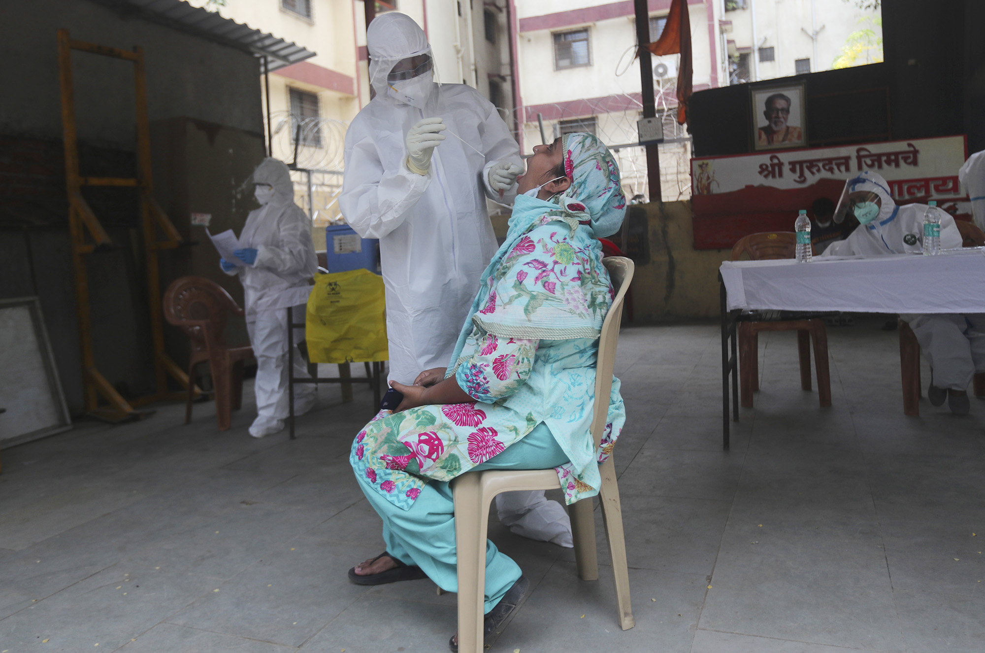 A health worker takes a swab test for the novel coronavirus of a woman during a free medical checkup in Mumbai, India, on Friday, June 26. 