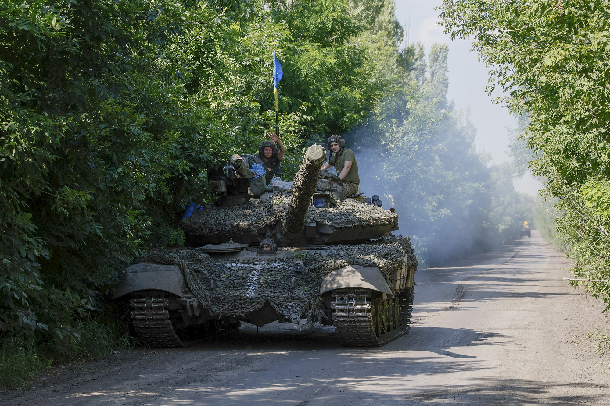 Ukrainian servicemen ride atop a T-64 tank at the front line near Bakhmut, Donetsk region, Ukraine, on July 3.