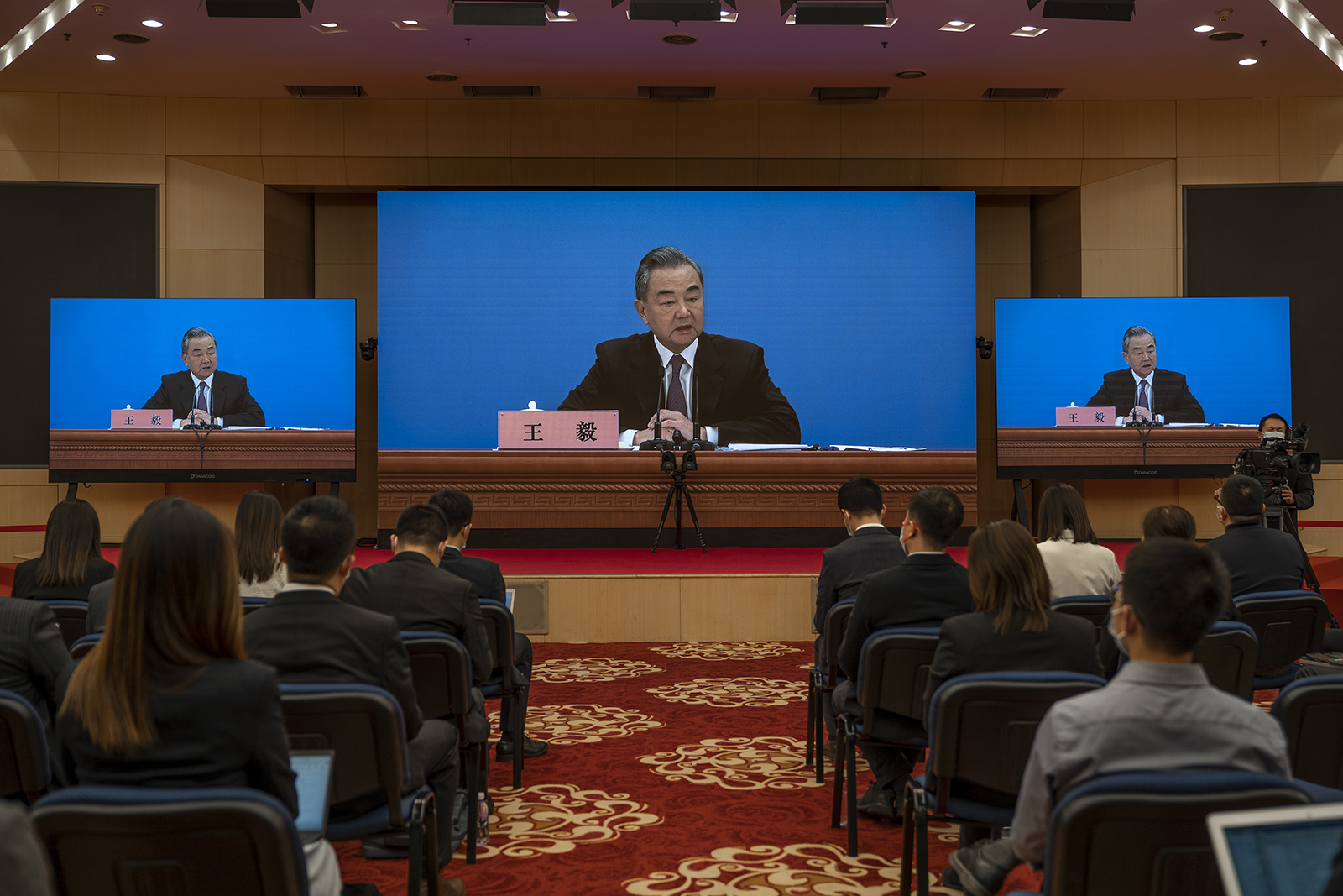 Chinese Foreign Minister Wang Yi is seen on screens during a press conference at the Media Center on March 7, in Beijing, China.