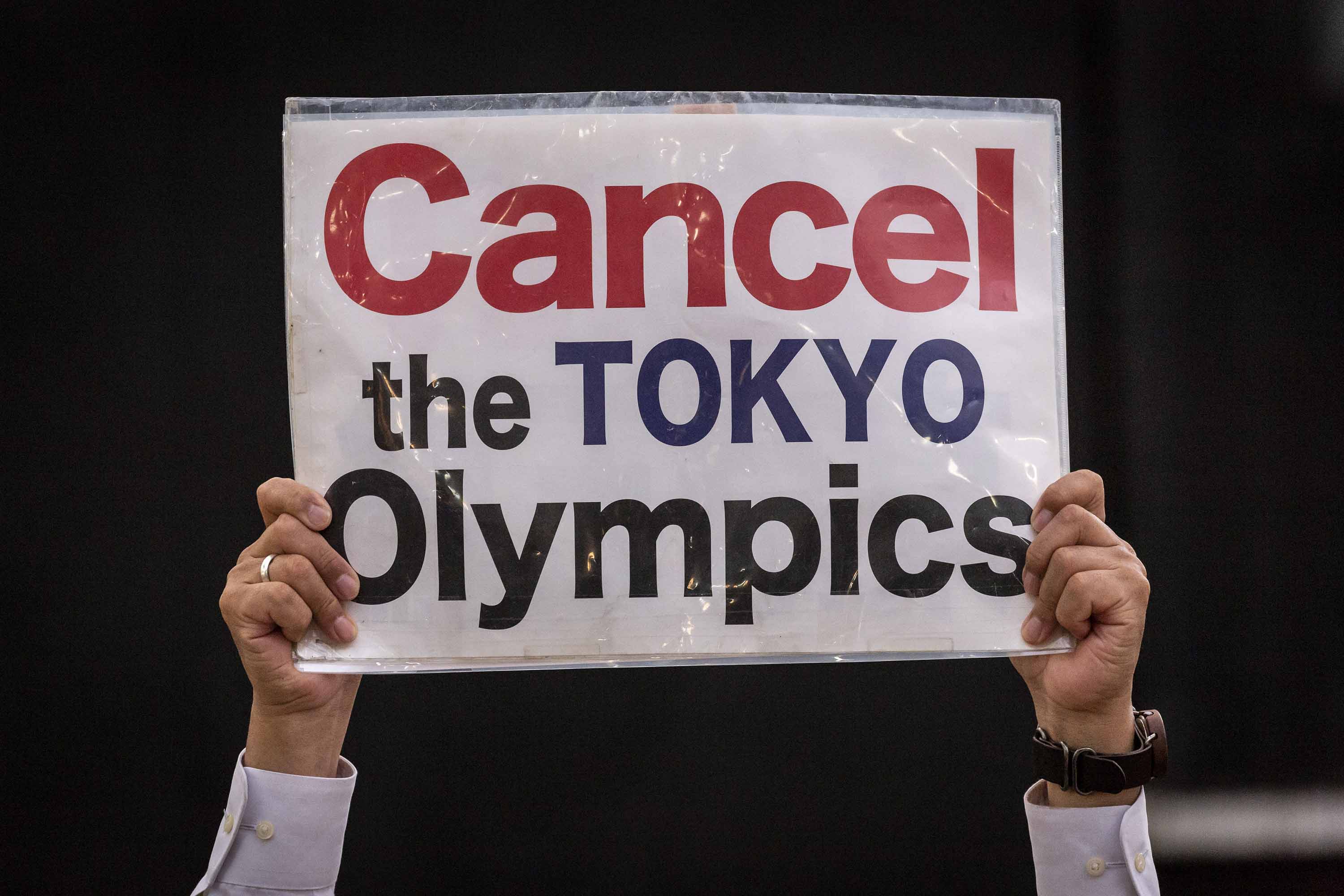 A protester holds a placard during a demonstration against the Tokyo Olympics on Monday, May 17, in Tokyo, Japan.