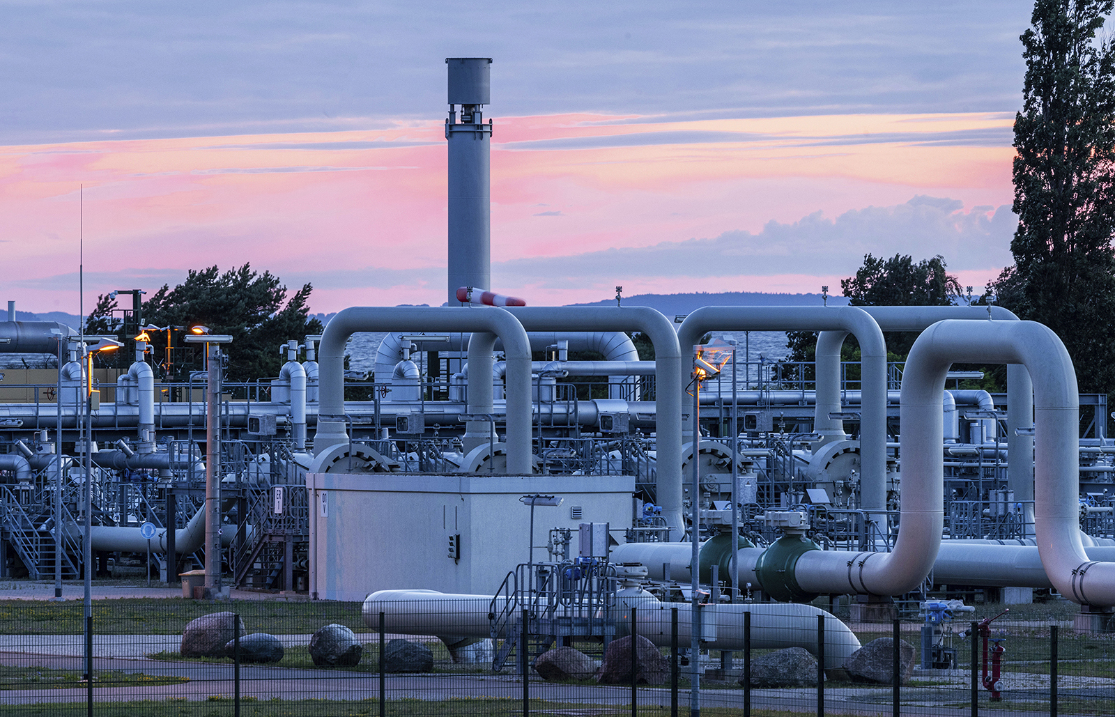 The sun rises behind the pipe systems and shut-off devices at the gas receiving station of the Nord Stream 1 Baltic Sea pipeline and the transfer station of the OPAL gas pipeline, Baltic Sea Pipeline Link, in Lubmin, Germany, on July 11.