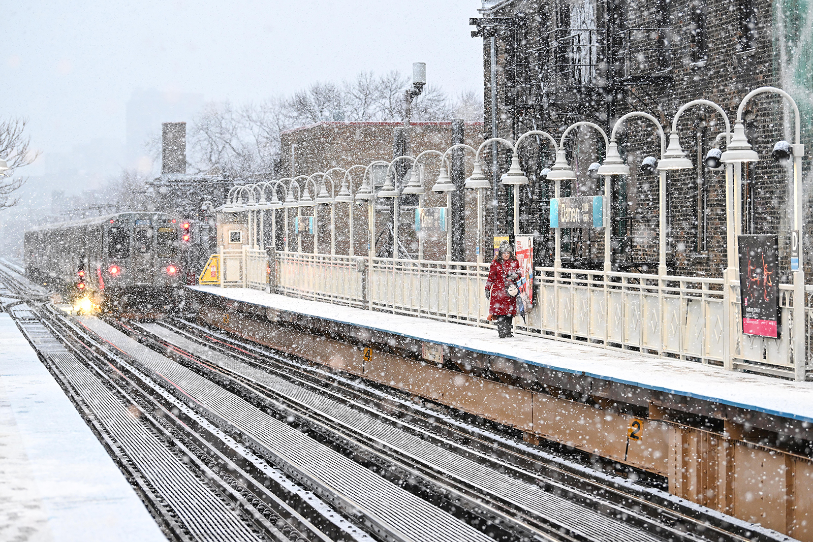 A commuter walks on the platform at the CTA Damen Blue Line station as it snows in Chicago on Tuesday.