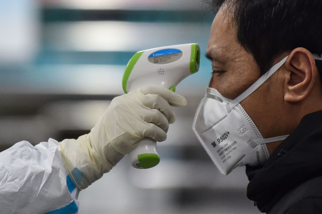 A medical staff member takes the temperature of a man at the Wuhan Red Cross Hospital on January 25.